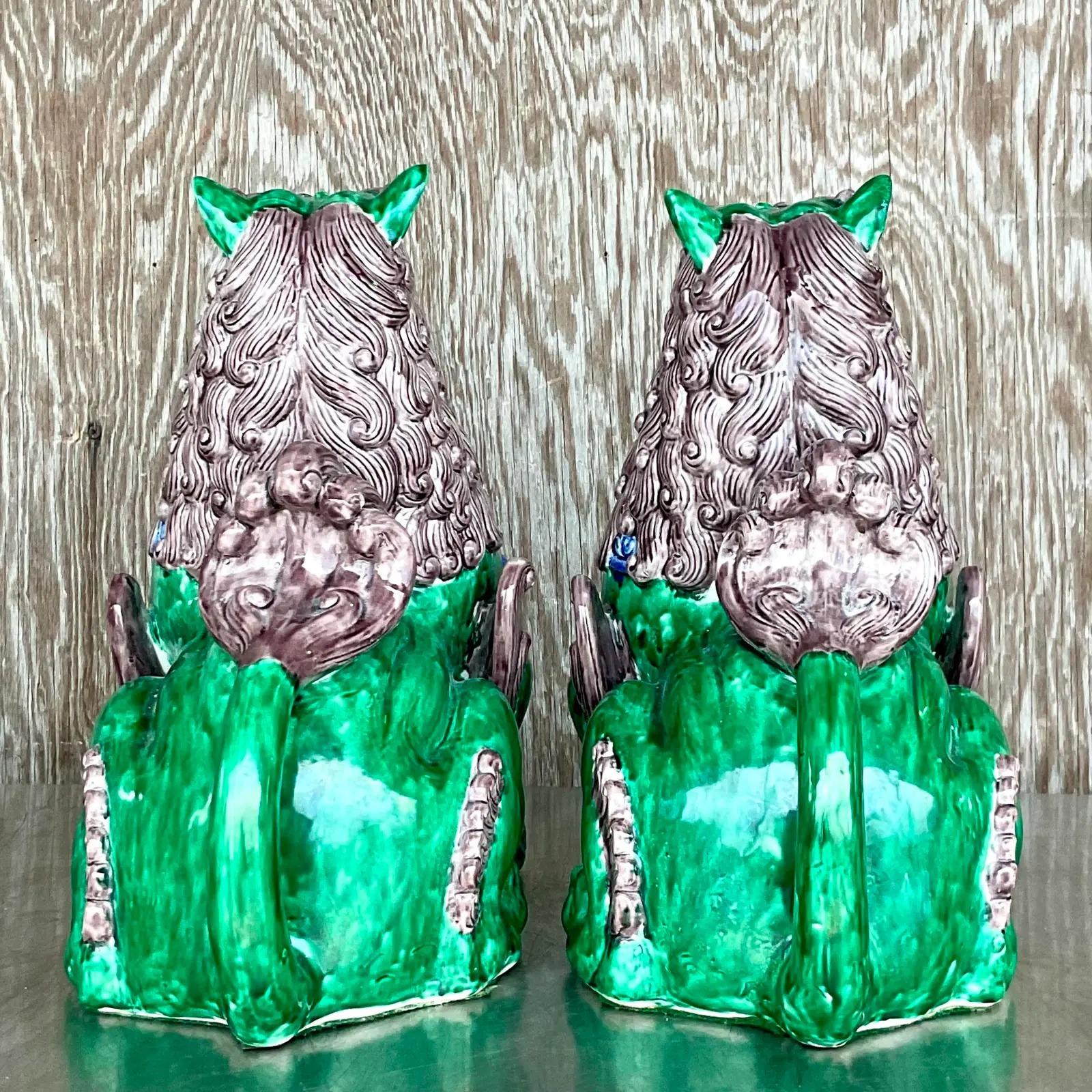 A fabulous pair of vintage Asian foo dogs. A chic glazed ceramic in bright clear colors. Two expressions add to the charm. Acquired from a Palm Beach estate.