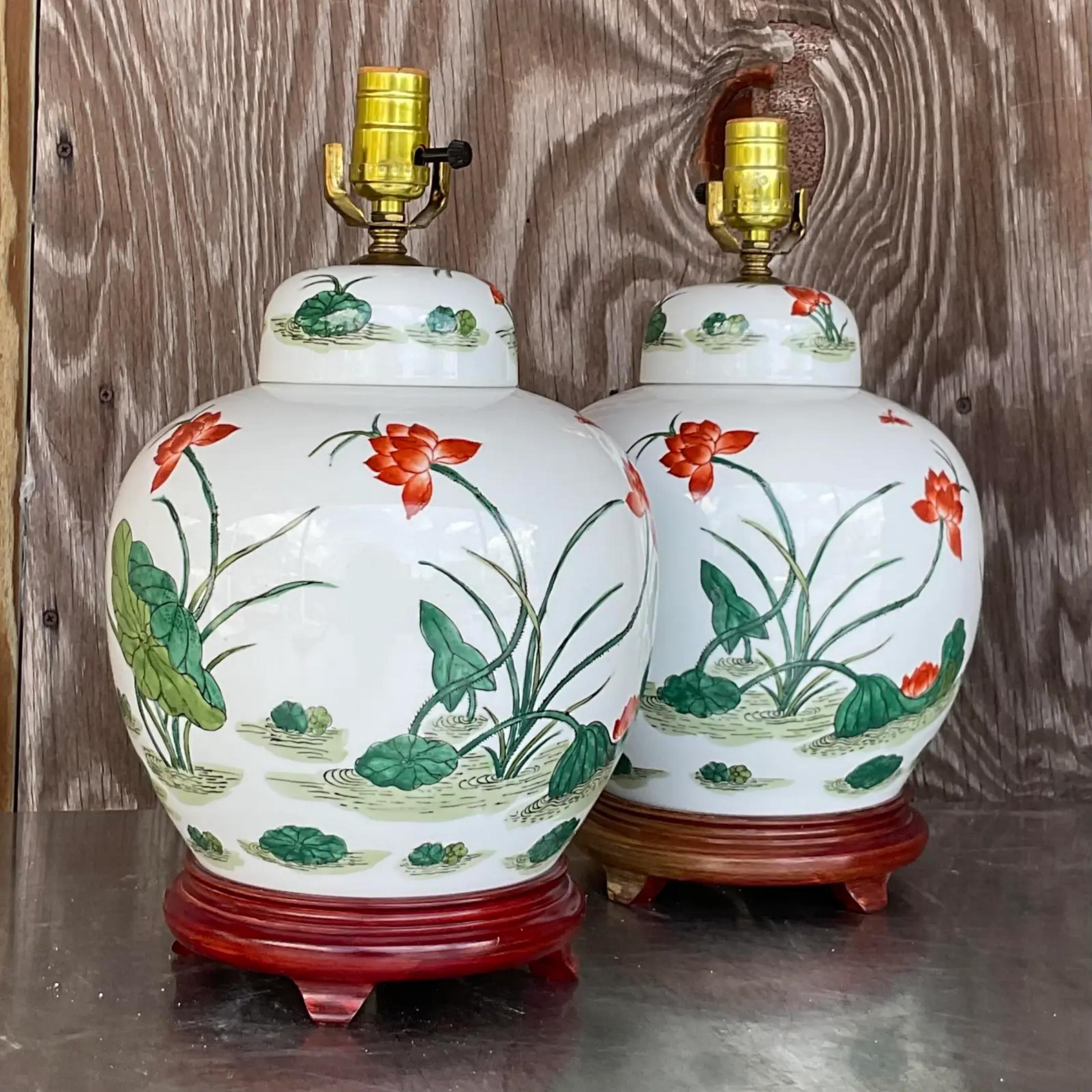 A fabulous pair of vintage Asian Floral lamps. A chic ginger jar shape with a glazed ceramic finish. Rest of wooden plinths. Acquired from a Palm Beach estate.