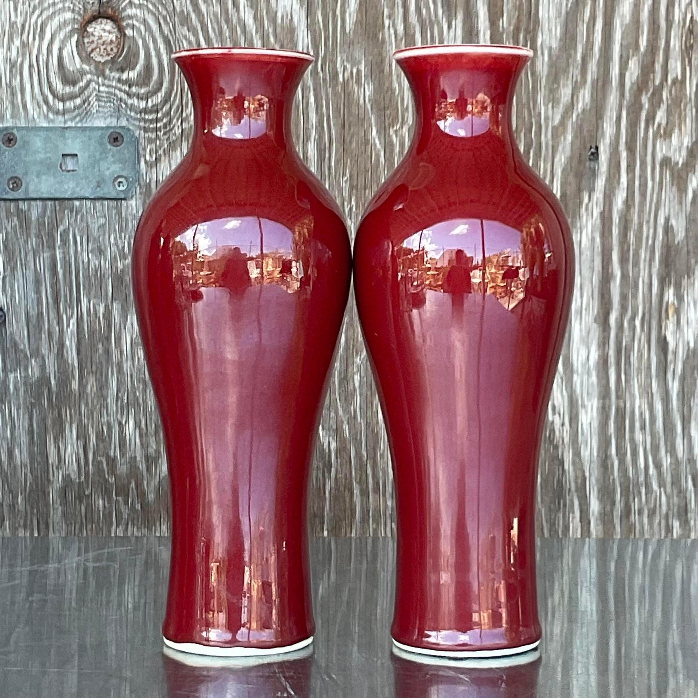 A fabulous pair of vintage Asian vases. A chic SDB glazed ceramic in a brilliant deep red color. Done in the glaze style of the iconic “Sang De Boeuf” vases. Acquired from a Palm Beach estate.