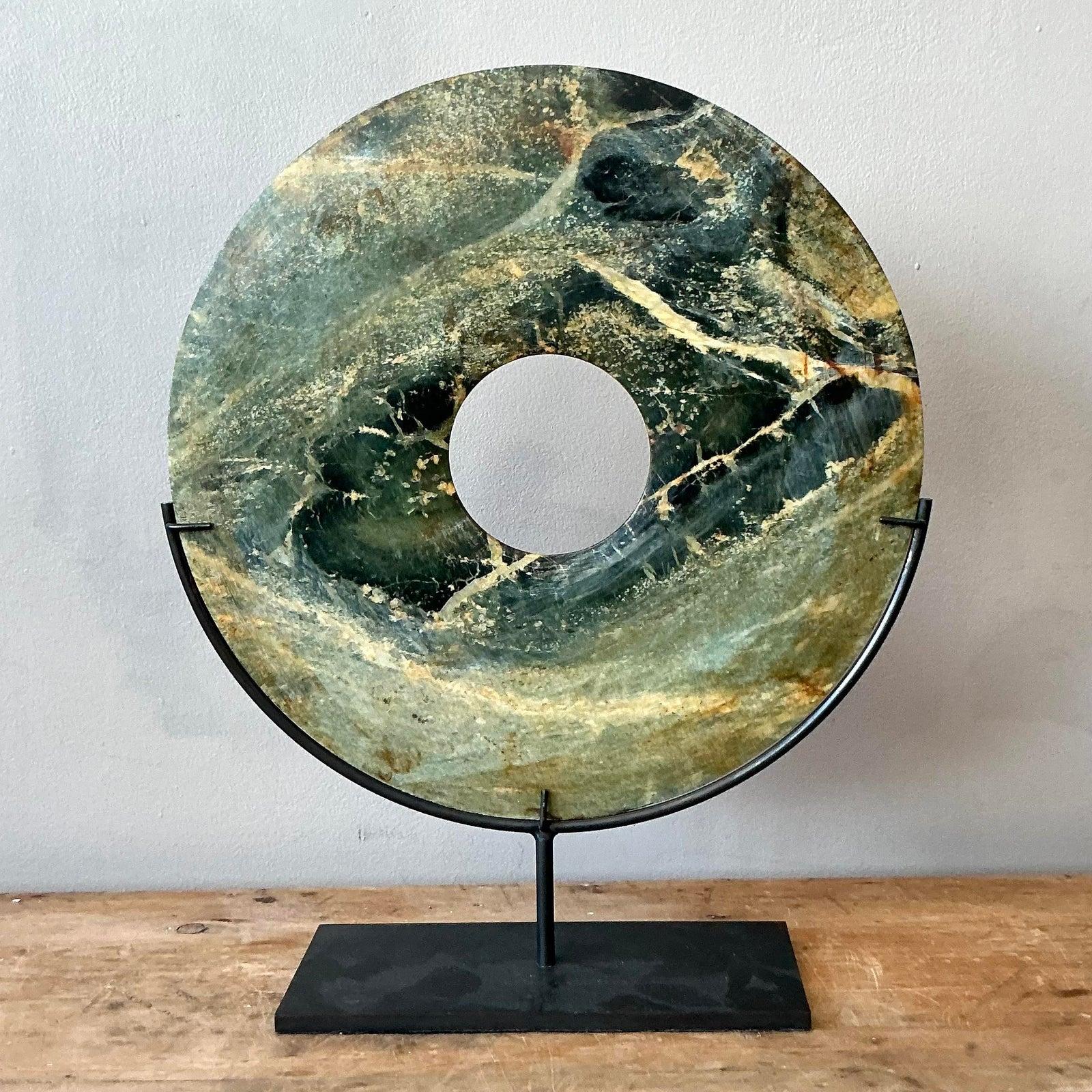 Ti presentiamo un affascinante bi-disco vintage in marmo verde asiatico, un oggetto decorativo di grande effetto che conferisce un'eleganza naturale e un antico simbolismo agli interni moderni. Questo squisito disco, realizzato con un ricco marmo
