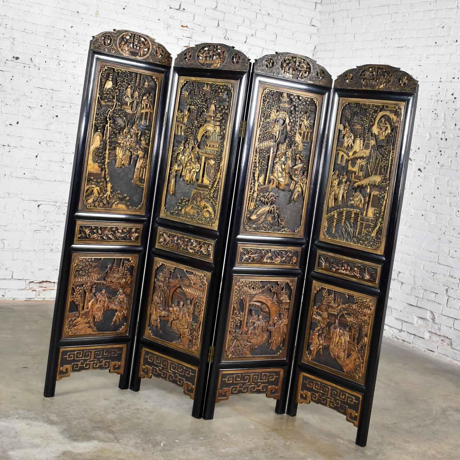 Handsome Asian folding screen or room divider with four amazing hand carved panels that are lacquered and gilded. It is in fabulous vintage condition with no outstanding flaws we have seen, circa mid-late 20th century. 

This is one of the most