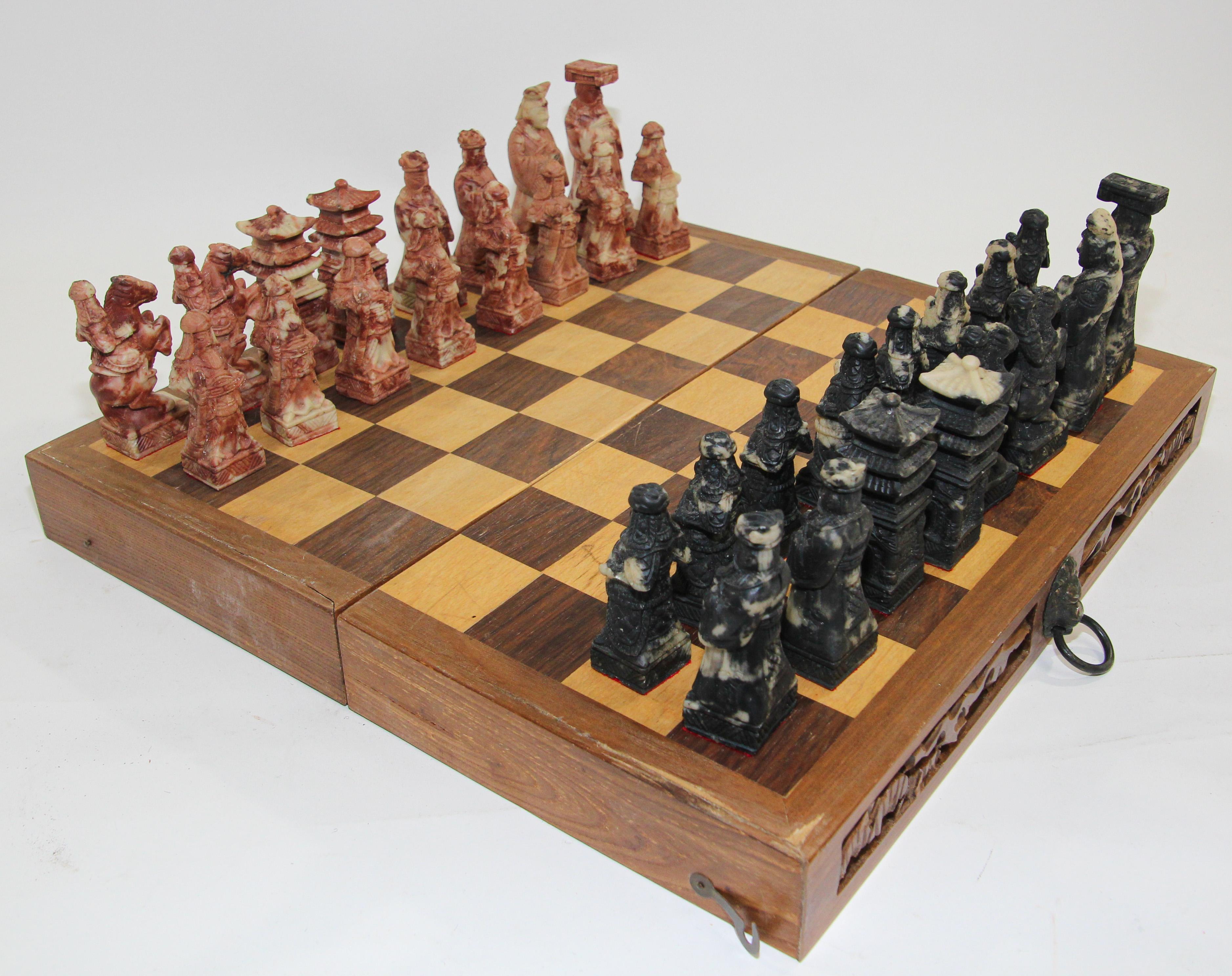Vintage Asian Hand carved Soap stone chess set in box.
The wooden box fold with the front hand carved and closing with a lion head design.
The board folds up for easy storage. Green felt house the chess pawns on each side. 
Hand-carved of soap