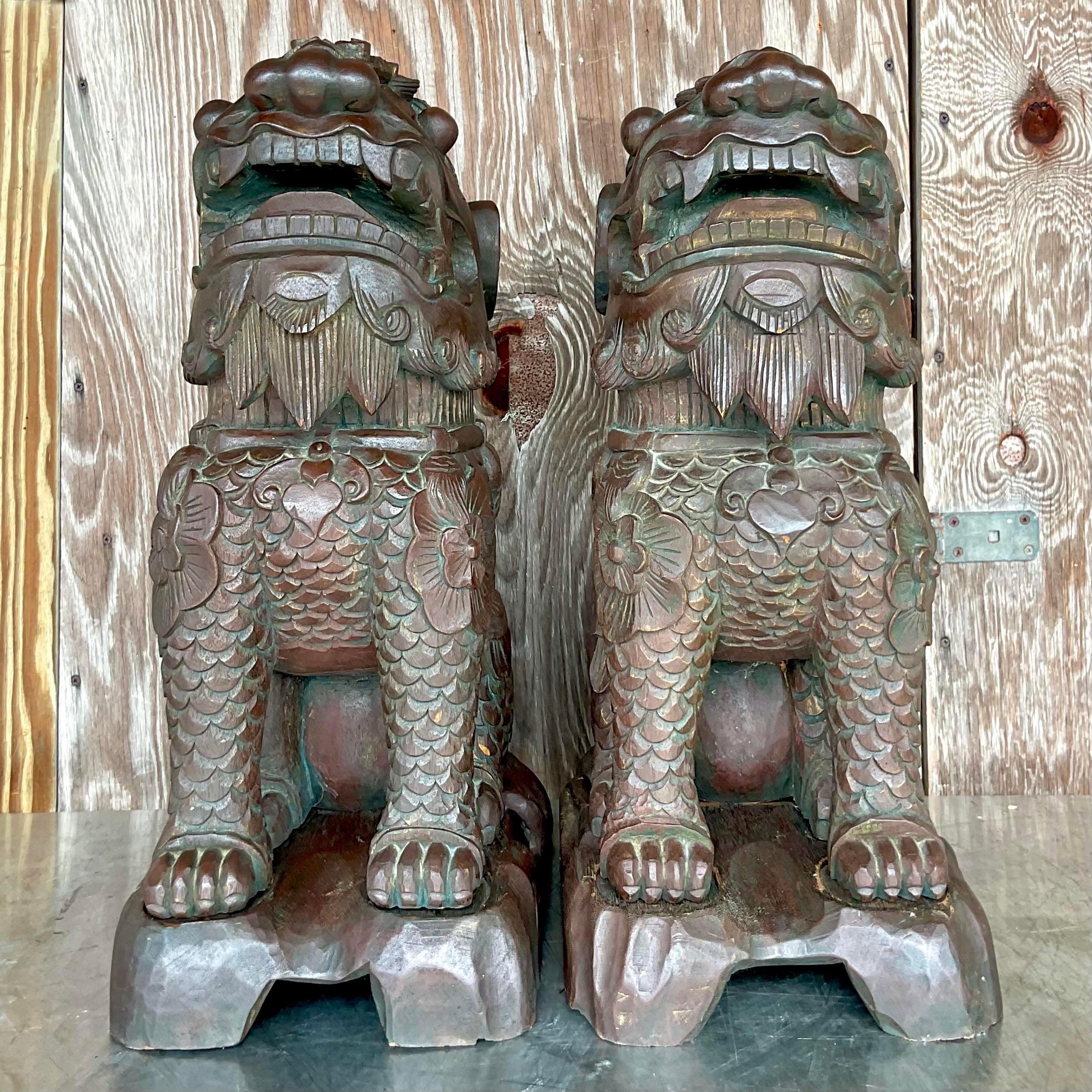A striking pair of vintage Asian Foo dogs. A beautiful hand carved pair with incredible attention to detail. Monumental in size and drama. Acquired from a Palm Beach estate.