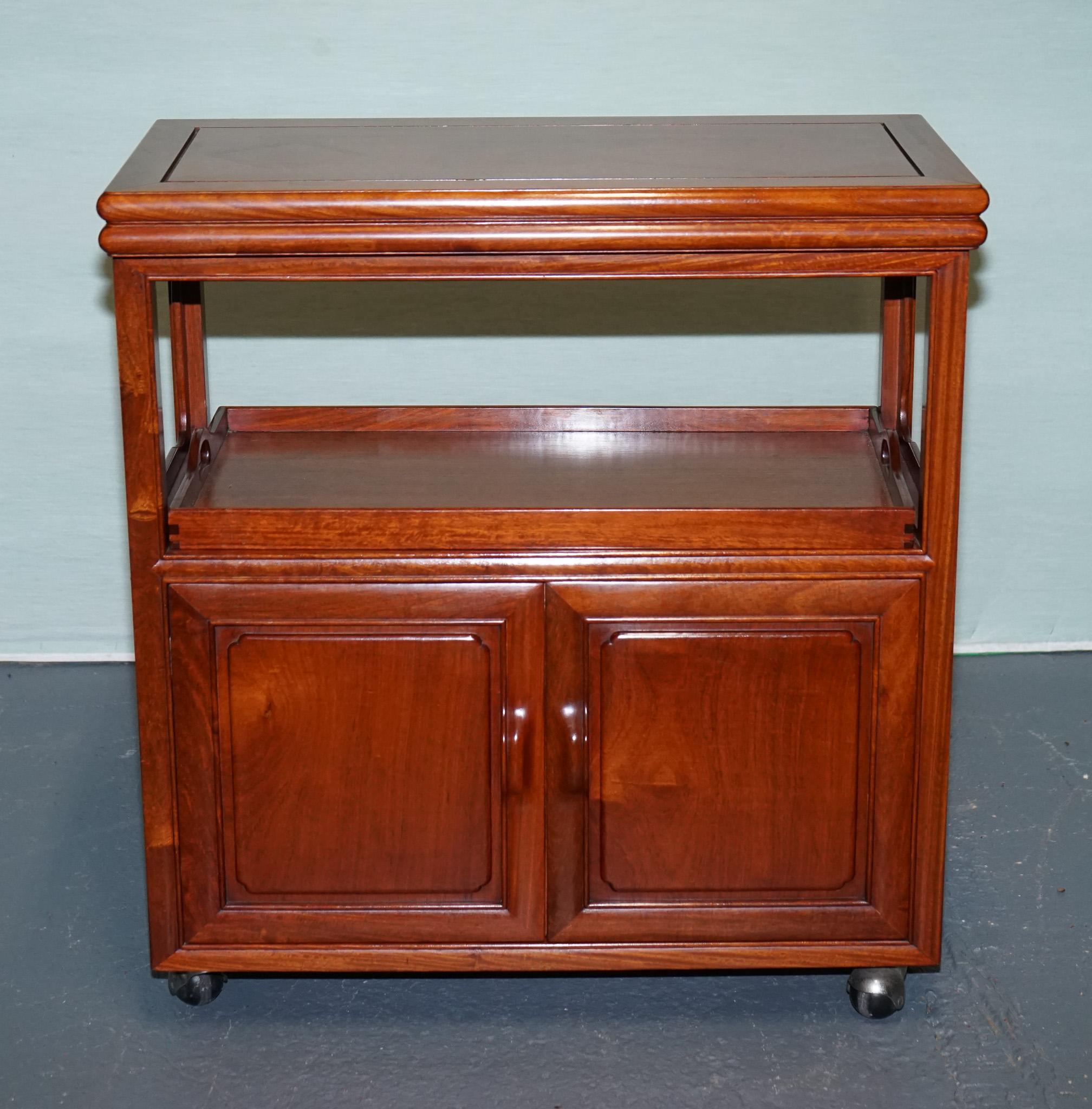 
Antiques of London



This vintage Asian-inspired rolling bar cabinet, dating from the mid-20th century, combines refined elegance with practical functionality. Crafted from richly grained hardwood, it displays a warm patina that speaks to decades
