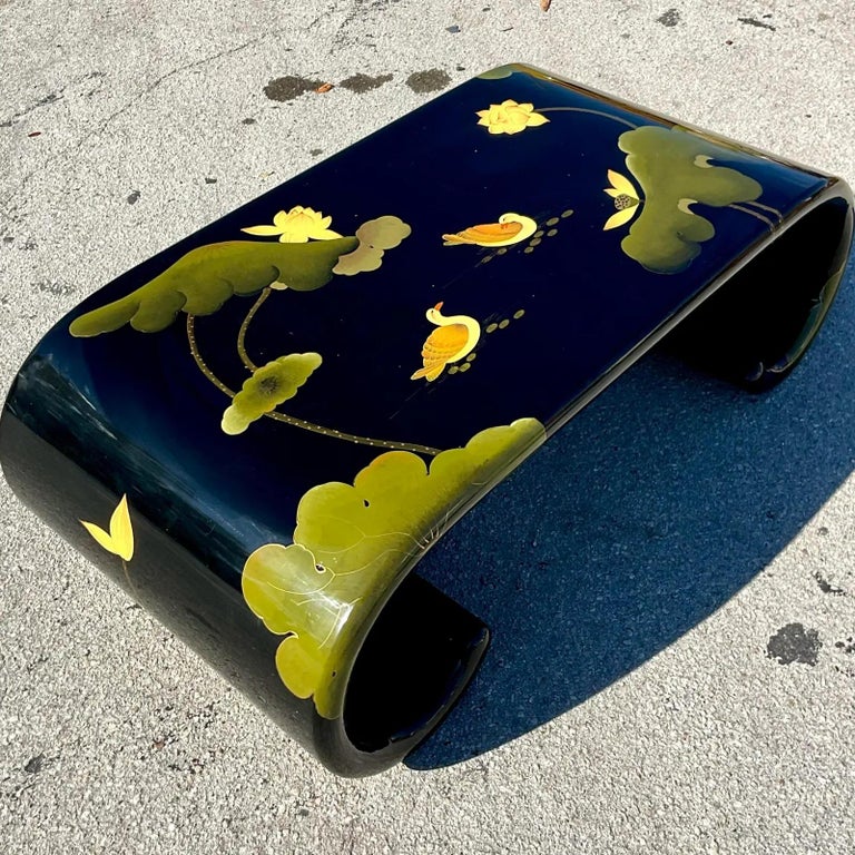 A fabulous vintage Asian Scroll lacquered coffee table. A chic scroll design with beautiful Mandarin ducks and lily pads. Acquired from a Palm Beach estate.