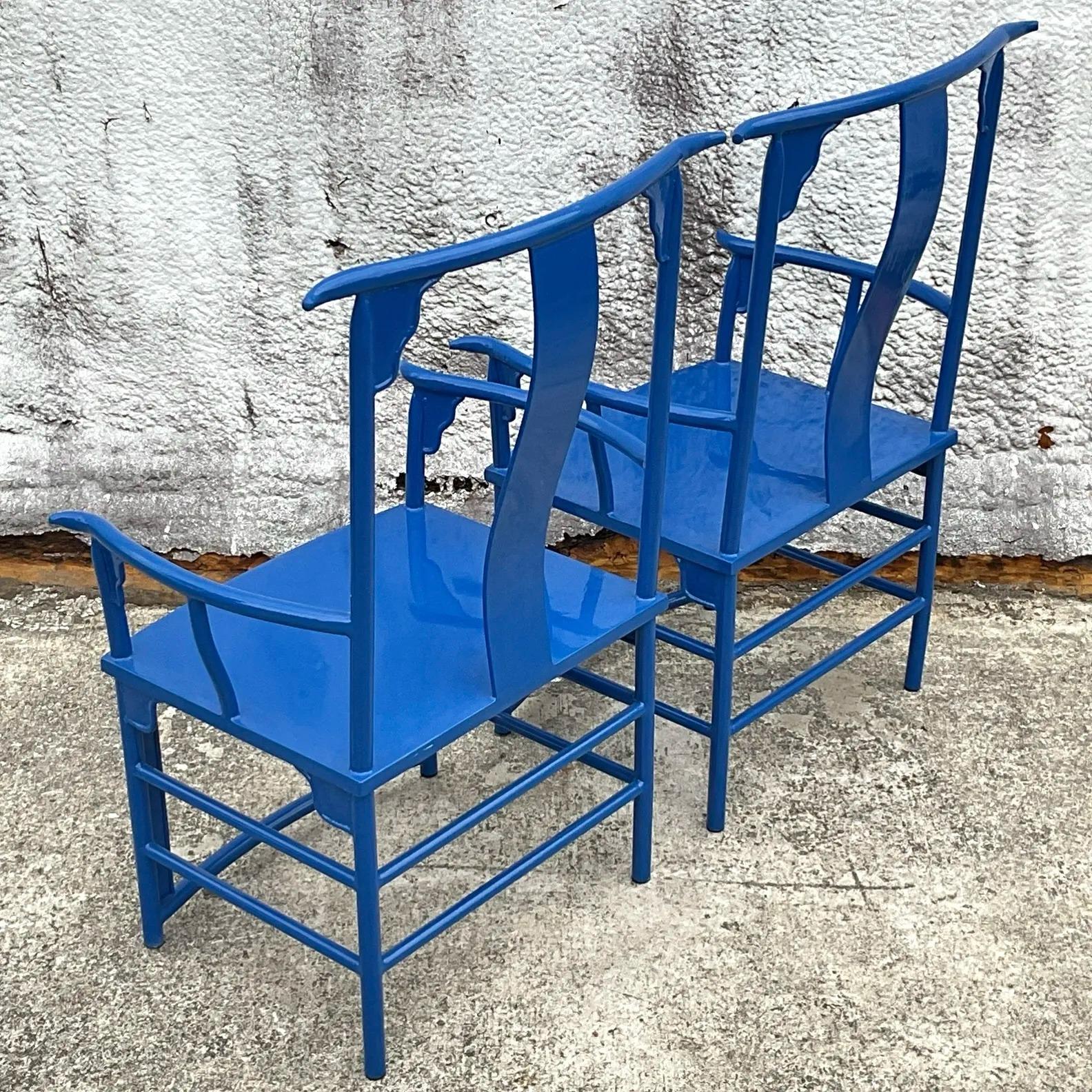 A stunning pair of vintage Asian-inspired emperor chairs crafted from lacquered metal, showcasing intricate detailing and a bold, regal design. These chairs feature a timeless blend of artistry and craftsmanship, with elegant curves and ornate