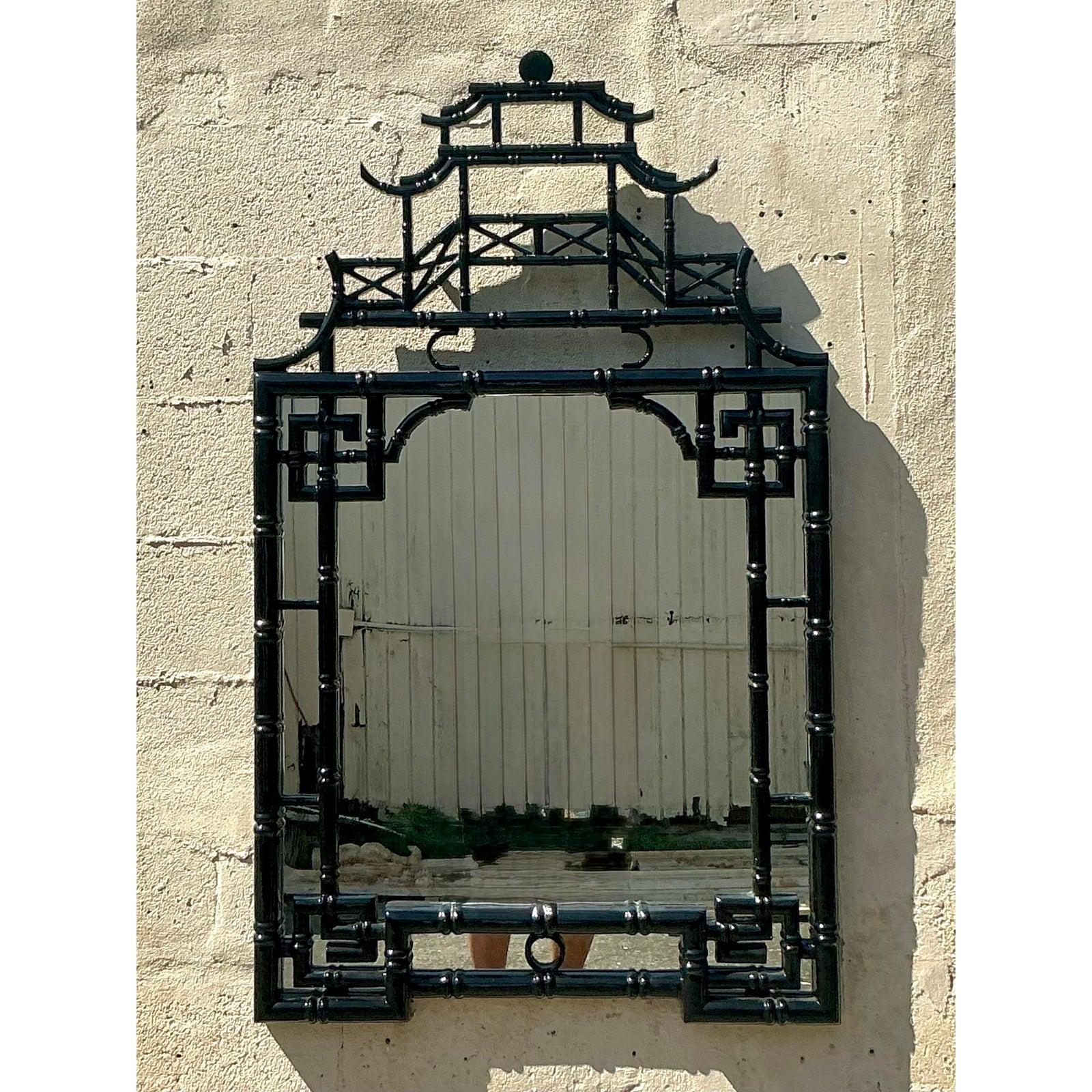 Add an extraordinary statement piece to your interior with this exquisite vintage Asian lacquered pagoda mirror. Crafted with striking Chinoiserie flair, this mirror features a highly detailed pagoda top and faux bamboo frame, all finished in a