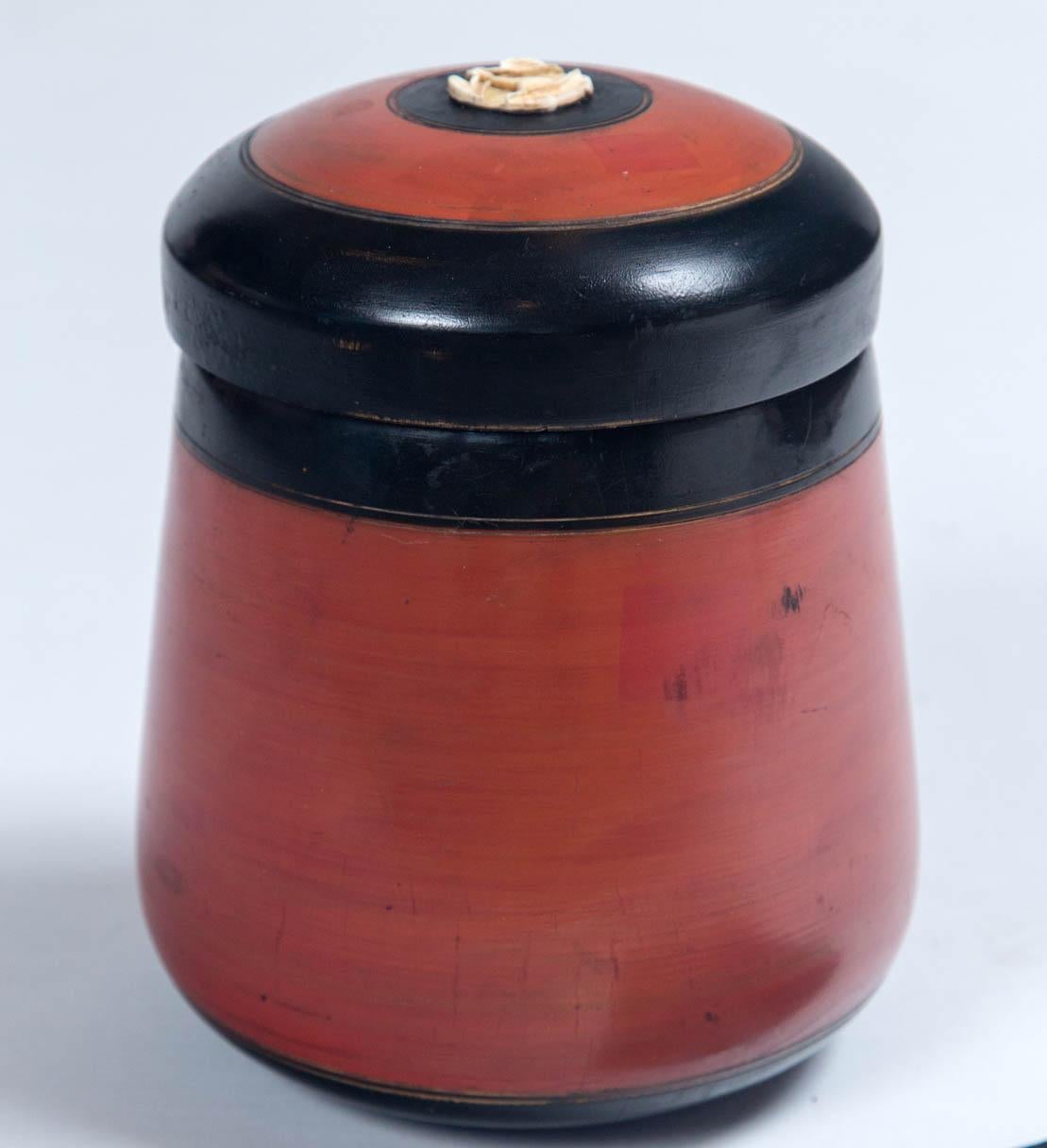 Vintage Asian lacquerware storage jar, 20th century. Hand-turned wood, cinnabar and black lacquer finish. Delicately carved floral inlay at center of lid.