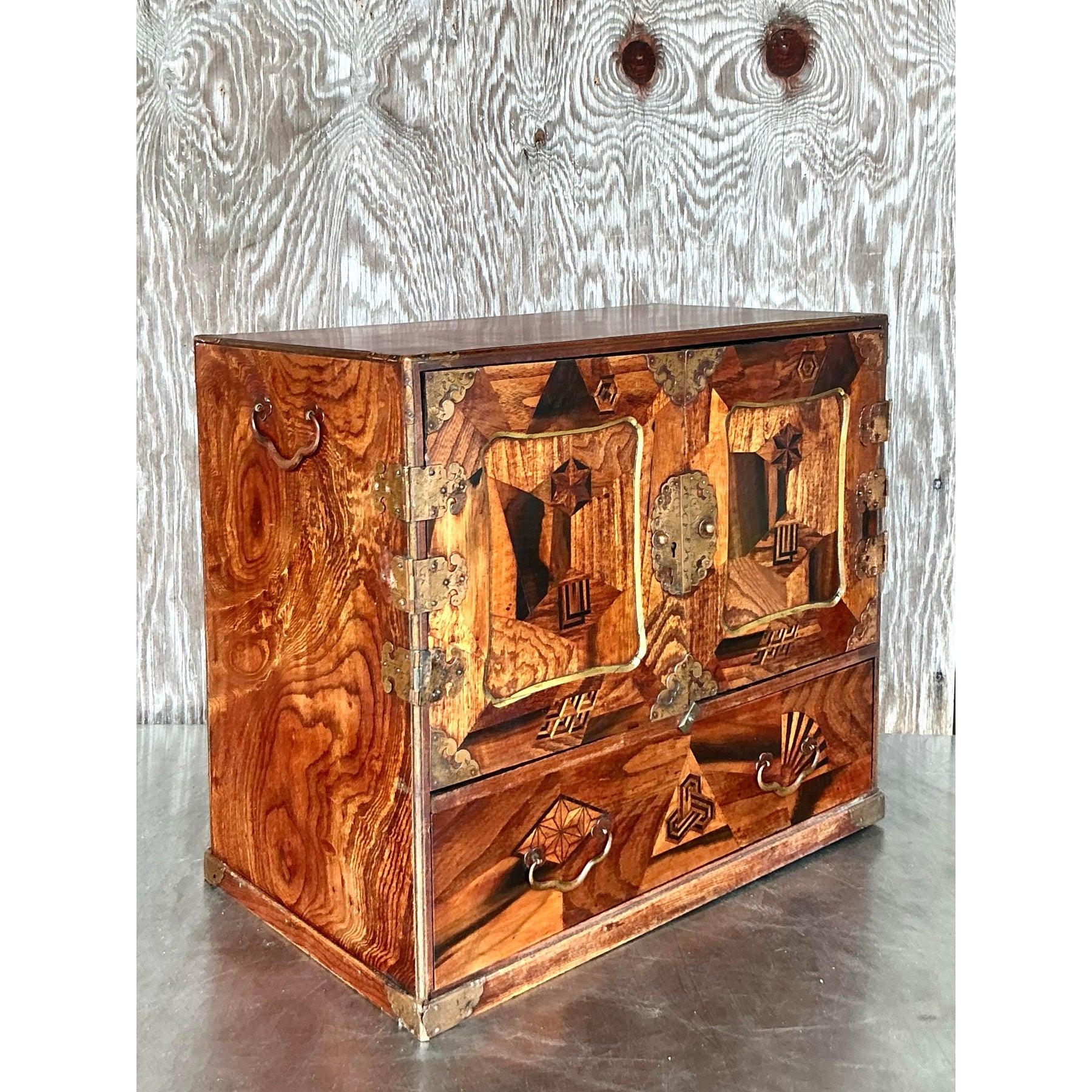 Questo squisito mobile da tavolo asiatico vintage con intarsio Tansu è una miscela magistrale di artigianato e funzionalità. Gli intricati intarsi formano splendidi motivi geometrici, mescolando le ricche tonalità del legno con il simbolismo