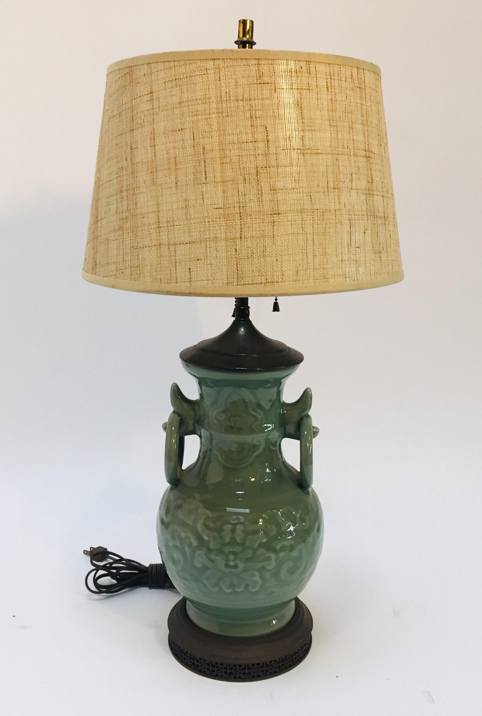 Vintage Asian oriental Chinese glazed jade green light celadon color with raised relief flowers handled vase porcelain lamp.
This beautiful piece is timeless in style.
Mounted on metal darkened base with Chinese cutouts designs.
The jar with