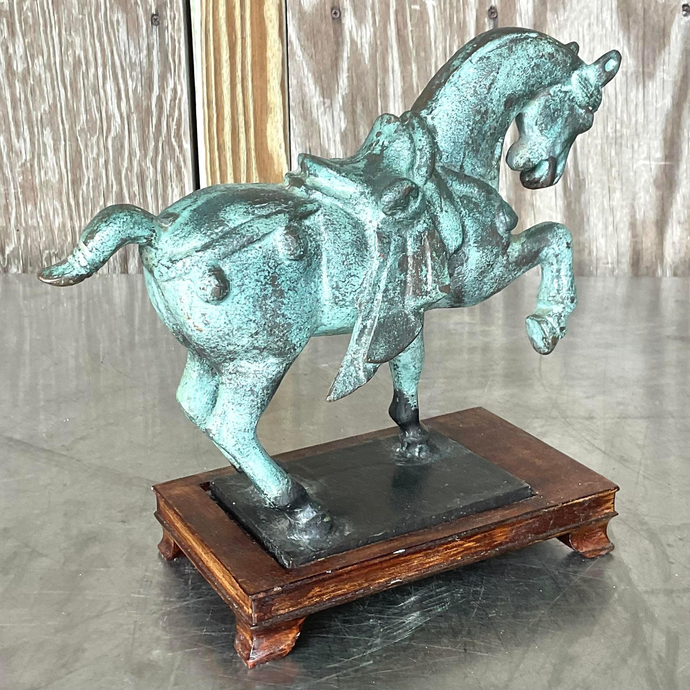 A gorgeous vintage Asian Tang Dynasty horse. A beautiful, patinated green finish on a solid metal horse. Rests on a reclaimed wood plinth. Acquired from a Palm Beach estate