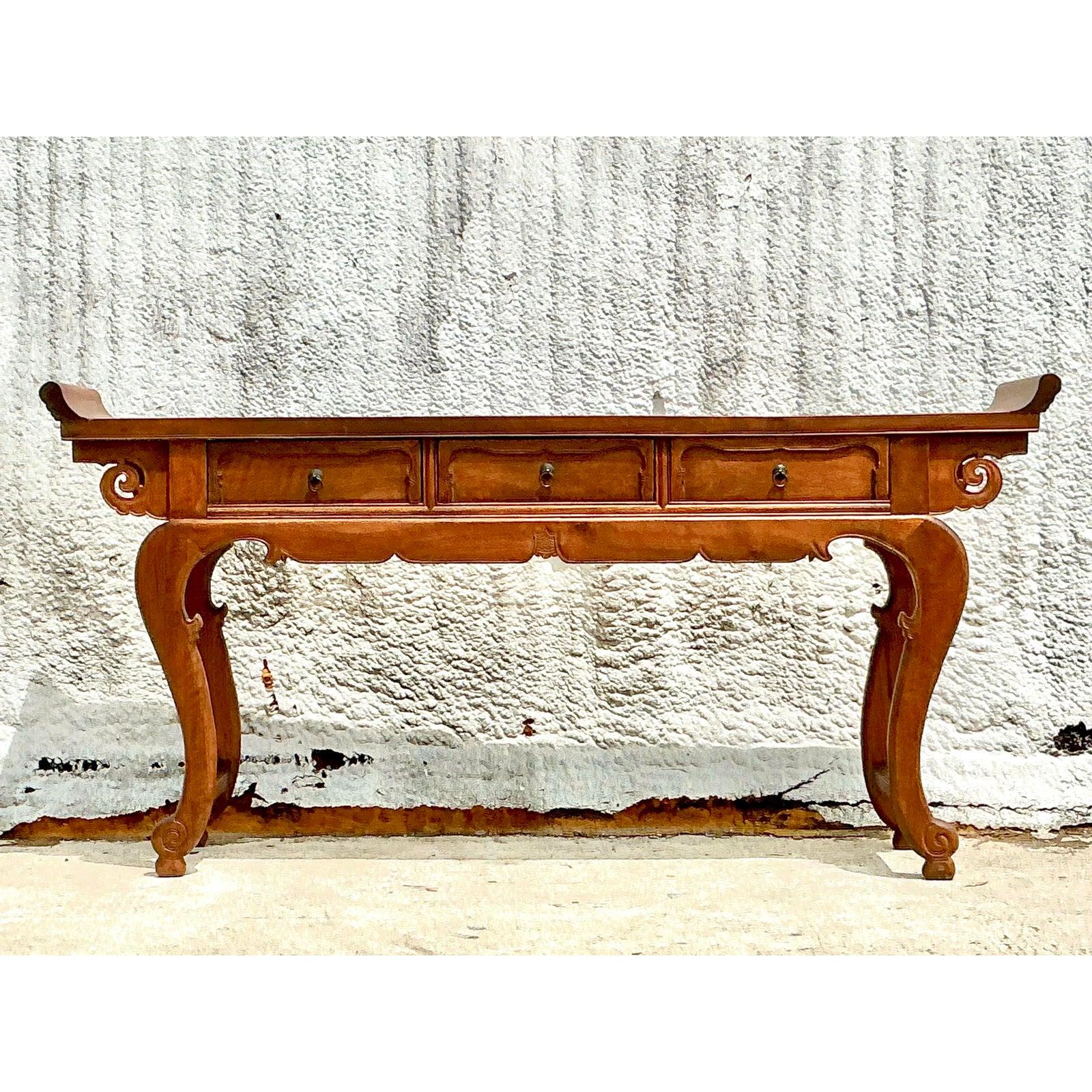 Infuse your space with the timeless elegance of this vintage Asian-style console table, crafted from richly toned reclaimed wood. The sculptural form features gracefully curved legs, intricate carved details, and a pagoda-inspired top edge that nods