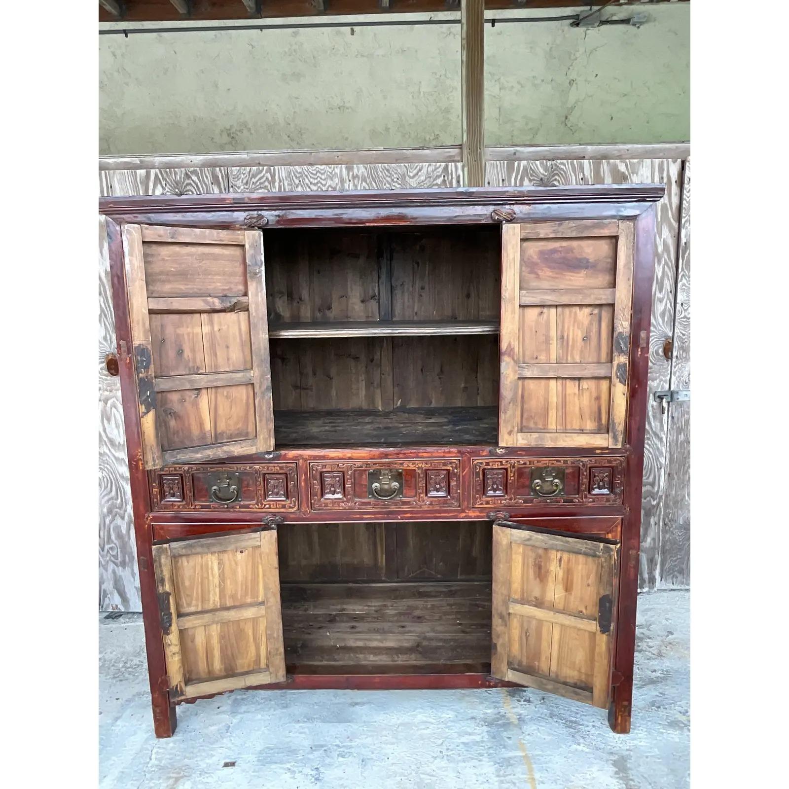 Stunning vintage Asian red lacquered cabinet. Glossy reclaimed wood carved with gorgeous little scenes. Gilt touches across the top. Lots of interior storage. A real showstopper that would make a fabulous dry bar. Acquired from a Palm Beach estate.