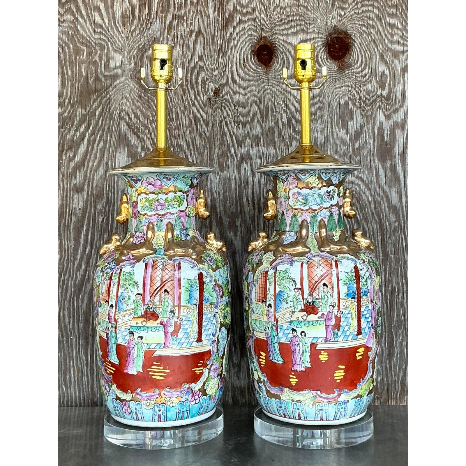 This exquisite pair of vintage Rose Famille lamps showcases breathtaking hand-painted porcelain adorned with intricate Chinese courtyard scenes, floral motifs, and gilded accents. Rich hues of red, green, blue, and gold bring these lamps to life,