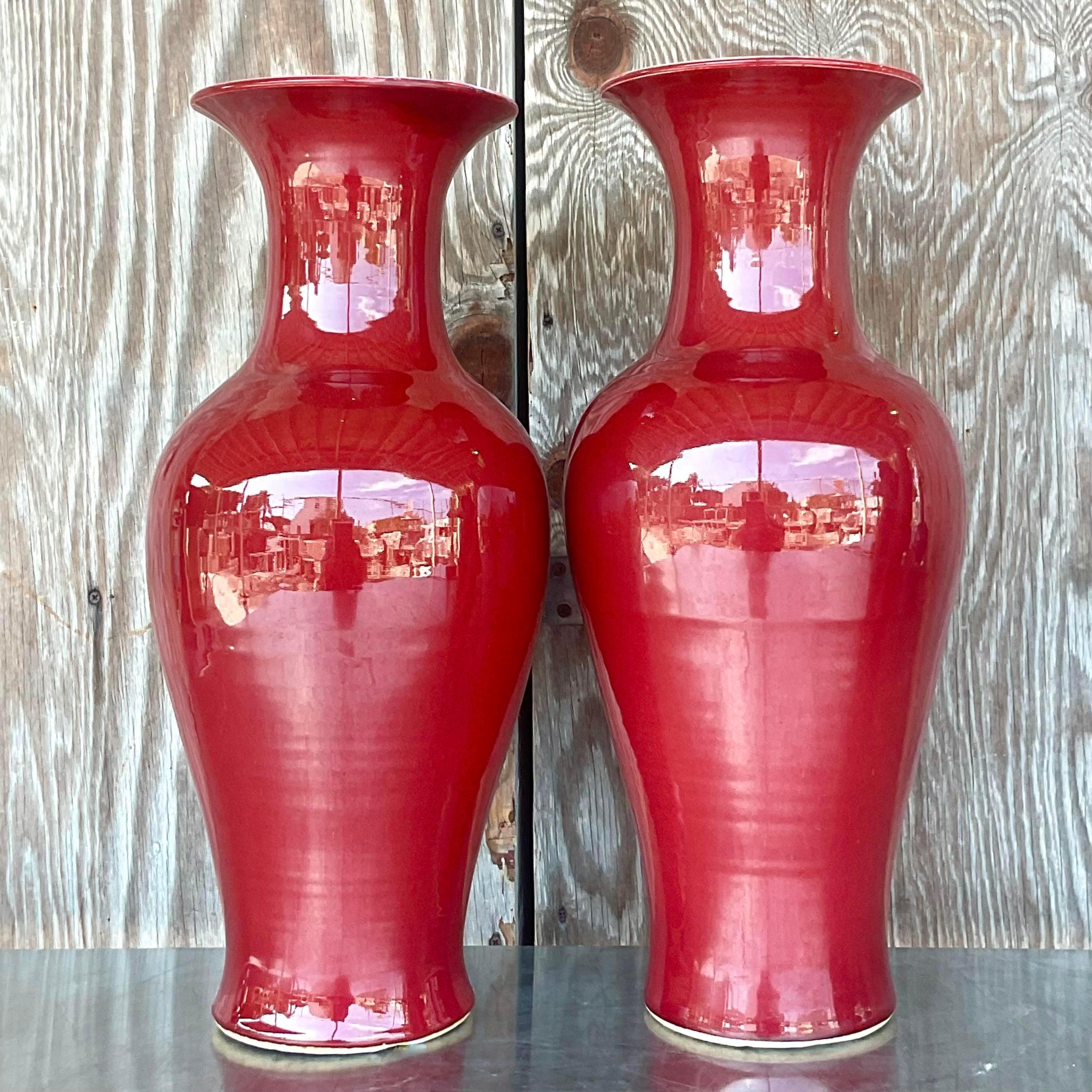 A gorgeous pair of vintage Asian vases. In a vibrant red that can be an amazing accent to any plain room. Acquired at a Palm Beach estate.