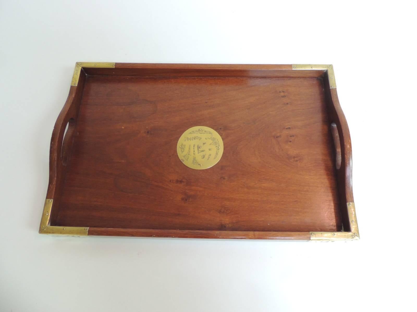 Vintage Asian serving tray with brass details
Wood rectangular Asian tray with centre brass medallion and brass fittings on the corners.
Two open handles on both sides.
Size: 11.5 x 17.5 x 2.
       