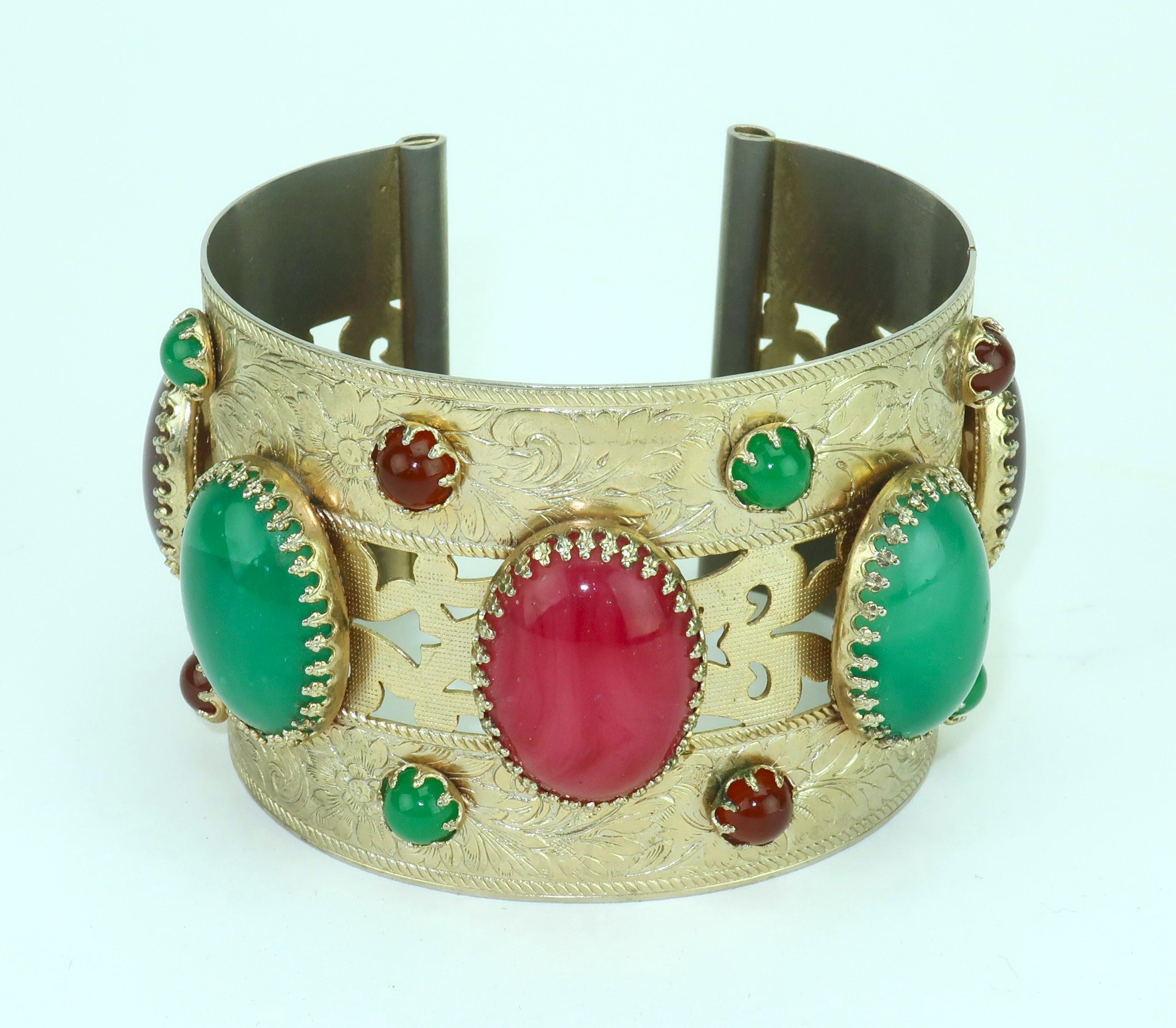 Funky chunky!  Bracciale in metallo dorato della metà del XX secolo con un motivo in stile asiatico e finte pietre cabochon che sembrano essere in resina nei toni del verde smeraldo e del rosso rubino.  Non c'è il marchio del produttore, ma è di
