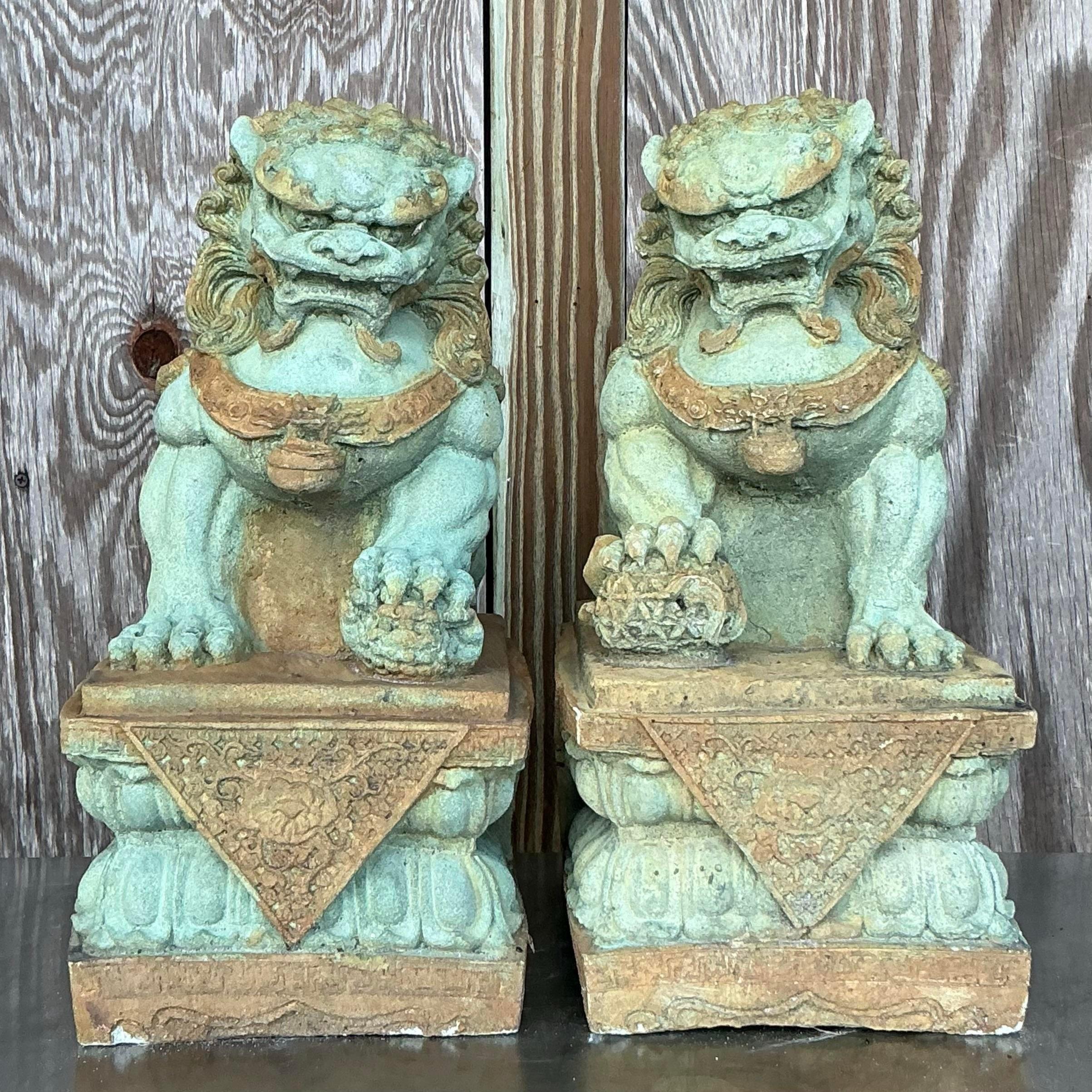 The Vintage Asian Tinted Cast Concrete Foo Dogs, a pair, blend Eastern mystique with American design sensibilities. These striking guardians, with their intricate detailing and tinted finish, add a touch of exotic elegance and protection to any home