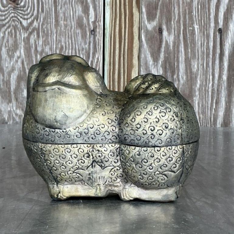 Añade un toque de herencia cultural y encanto a tu decoración con esta caja vintage asiática de metal labrado Foo Dog. Hábilmente elaborada, esta caja decorativa presenta intrincados detalles que muestran al mítico Perro Foo, símbolo de protección y
