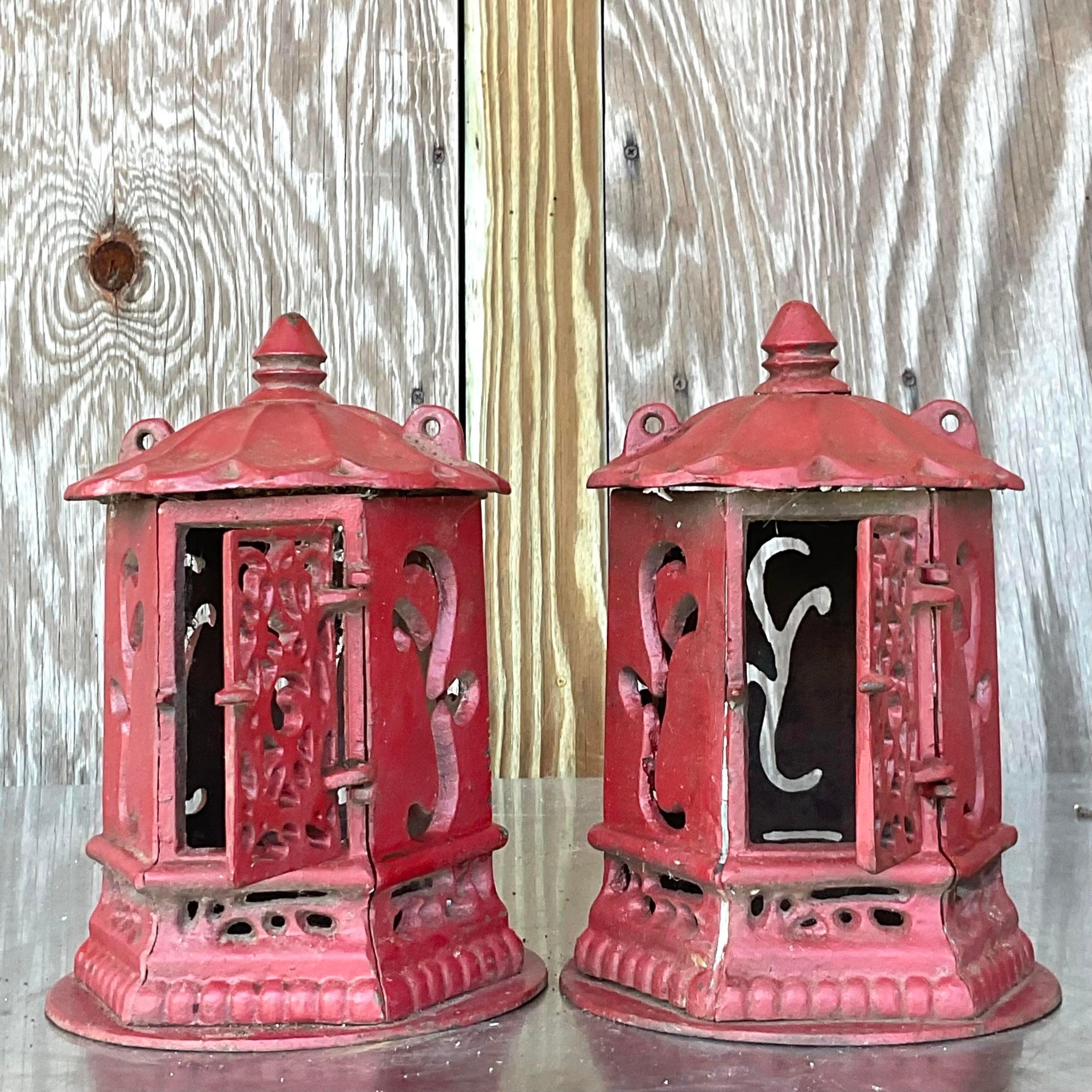 A fabulous pair of vintage MCM outdoor lanterns. A chic Asian pagoda design made in wrought iron. Painted a deep red that has mellowed over time to a fabulous shade. Acquired from a Palm Beach estate.