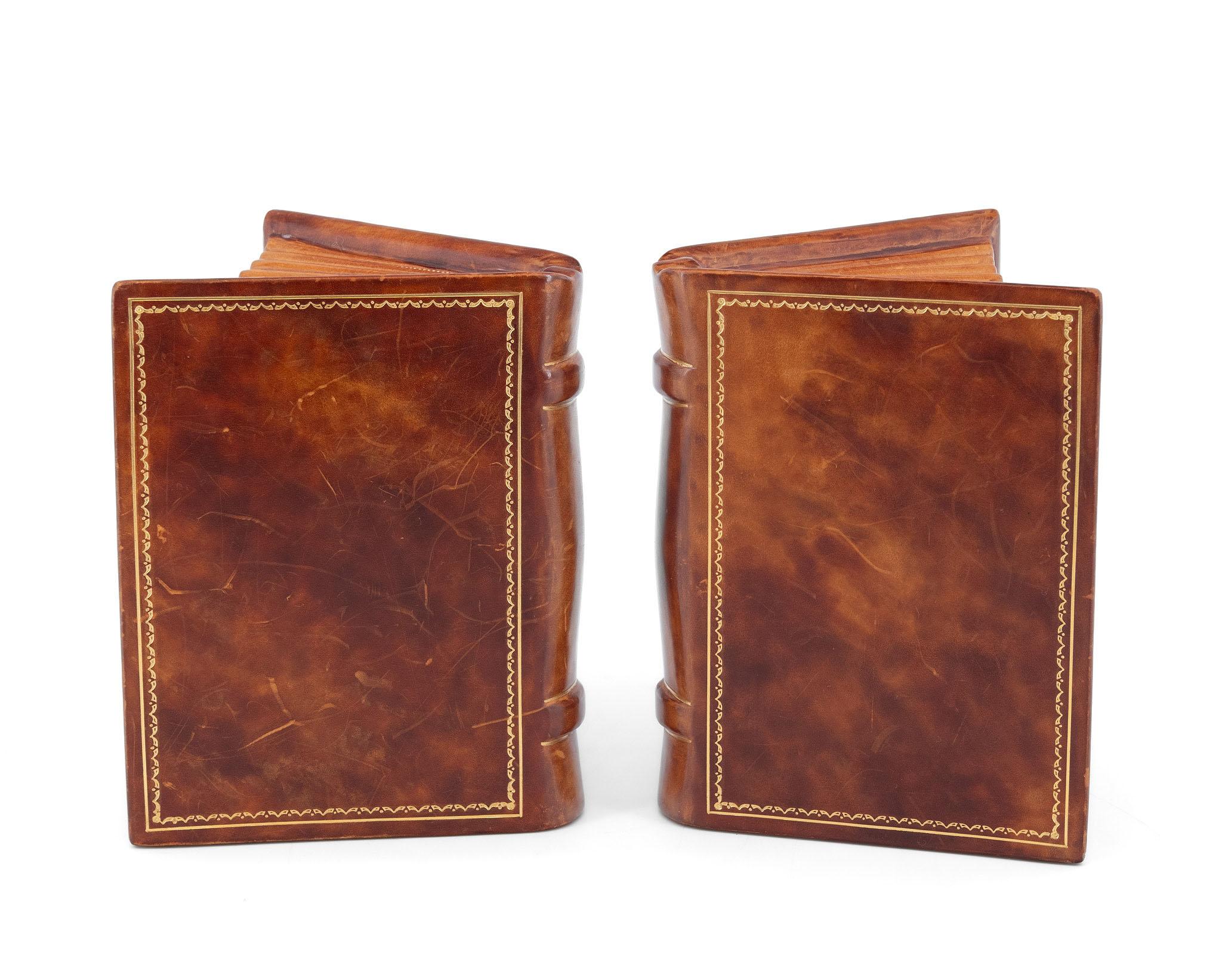 Reggilibri d'epoca Asprey & Co rivestiti in pelle con decorazioni dorate e basi in seta. Modellati come libri aperti. Timbri del produttore: Asprey & Co London. Circa 1970.

La pelle è posta su una base di legno e i fermalibri hanno un buon peso. Il