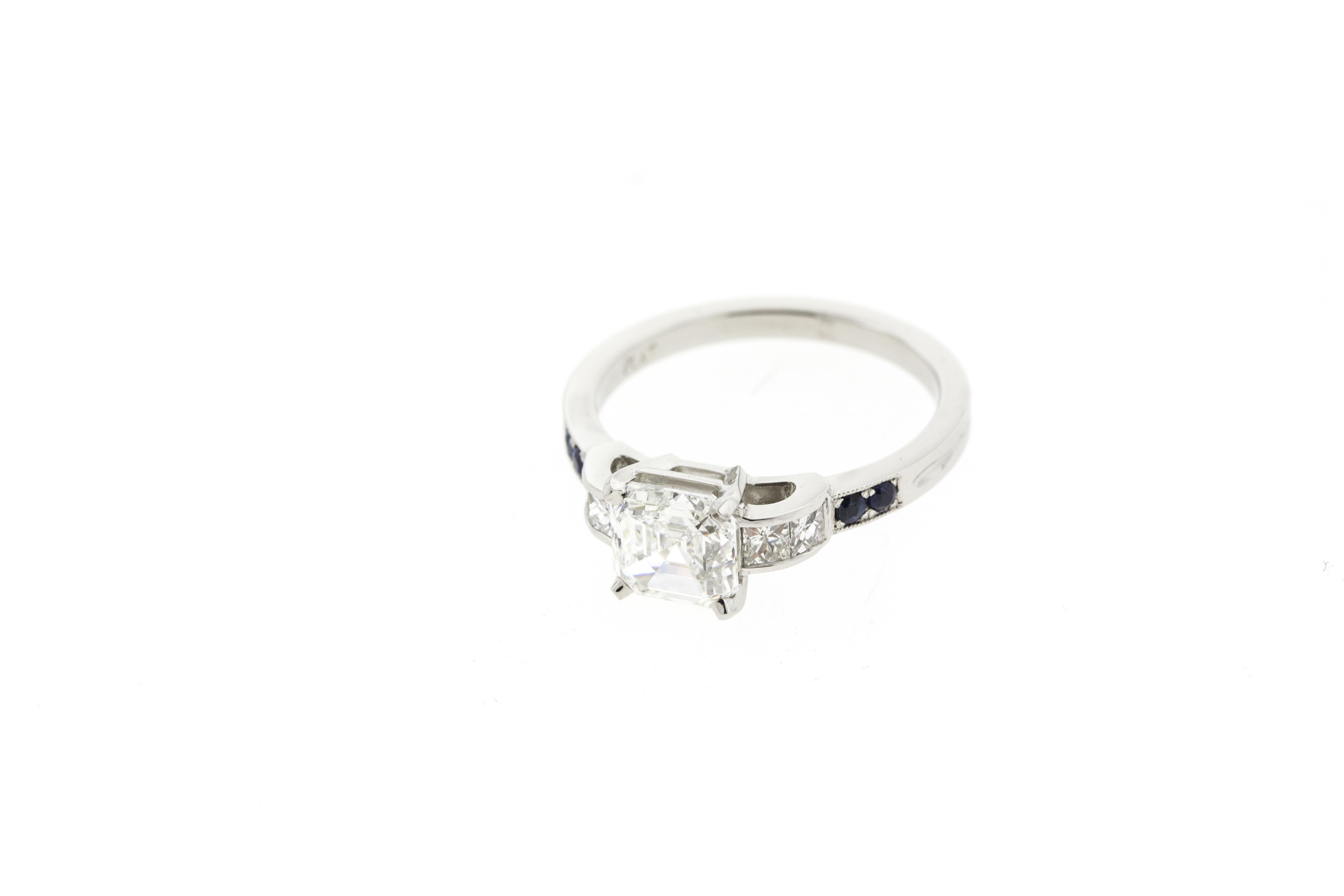 This asscher diamond engagement ring is made in platinum and features four additional channel-set side diamonds as well as four deep blue sapphires. A raised gallery and milgraine accents make this beautiful ring a must-have. 

Please note that each