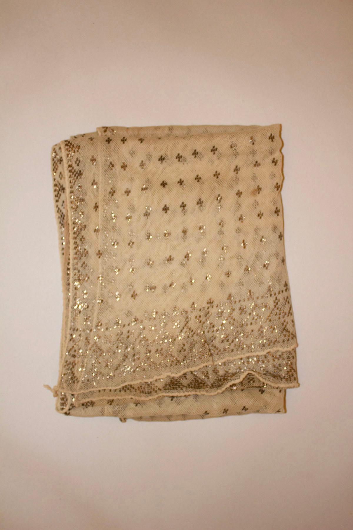 A wonderful vintage Assuit shawl. The shawl has an art deco design ,  in silver on the ivory  mesh. The decoration is in the centre and on the ends. Measurements: length 88''  x width 24''