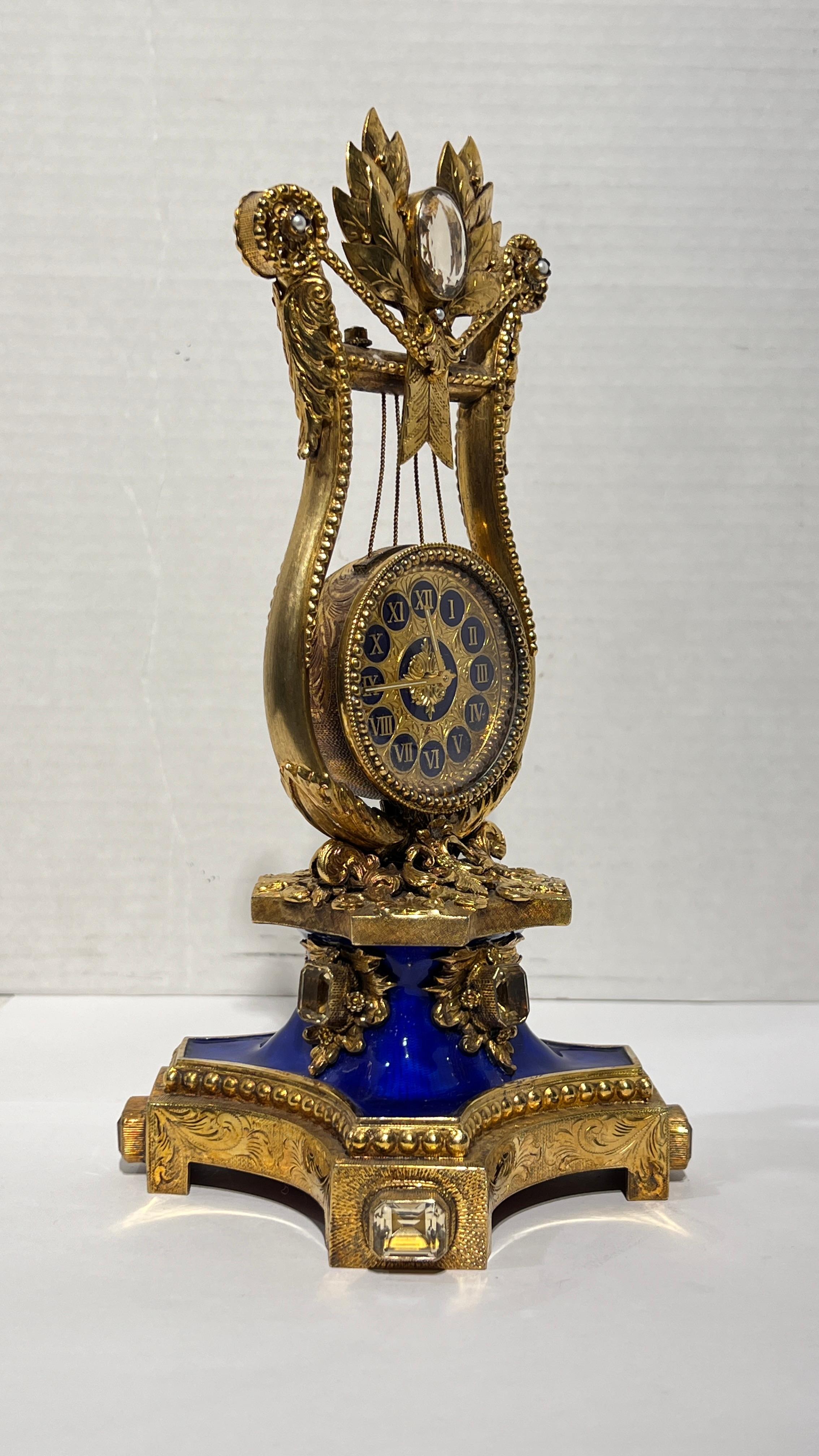 Lovely  musical Vintage Astro Hungerian Enameled Silver Gilt Musical Clock the movment is  by Reuge of Switzerland, of lyre form and exquisitely crafted from gilt silver with blue enamel and inset glass jewels.  Music box in fine working order.  