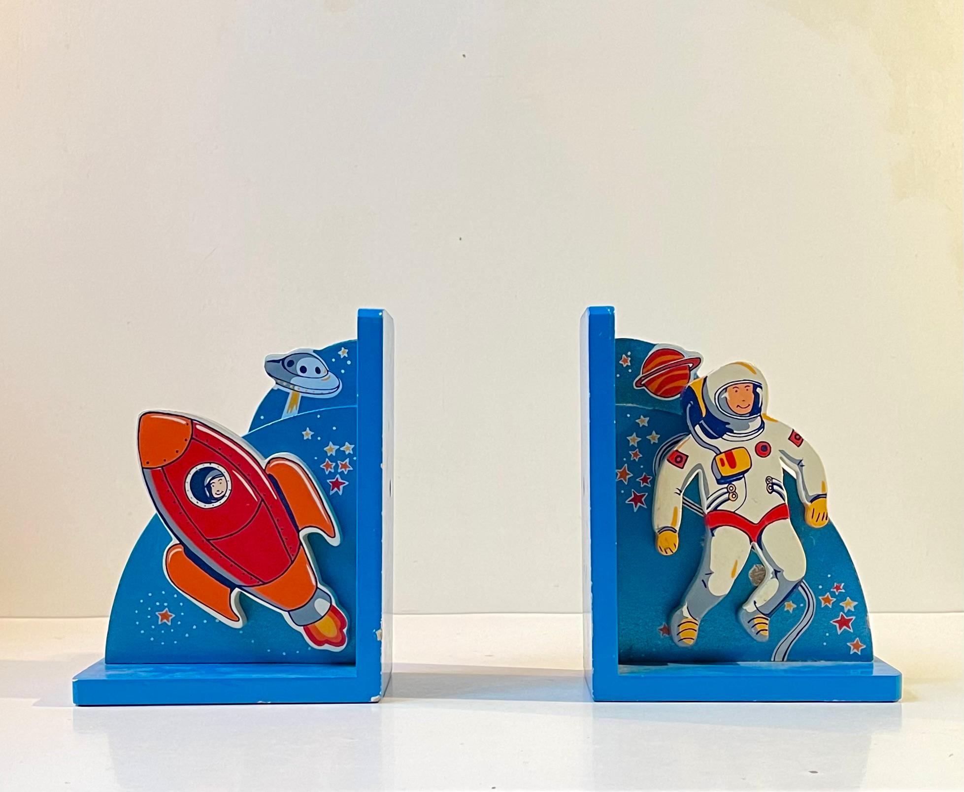 A set of Scandinavian Bookends in lacquered wood. The space theme is perfect for any little aspiring pilots room. The rocket and astronaut are placed in front of the backgrounds giving them a 3-d effect. The astronaut can be adjusted/tilted.