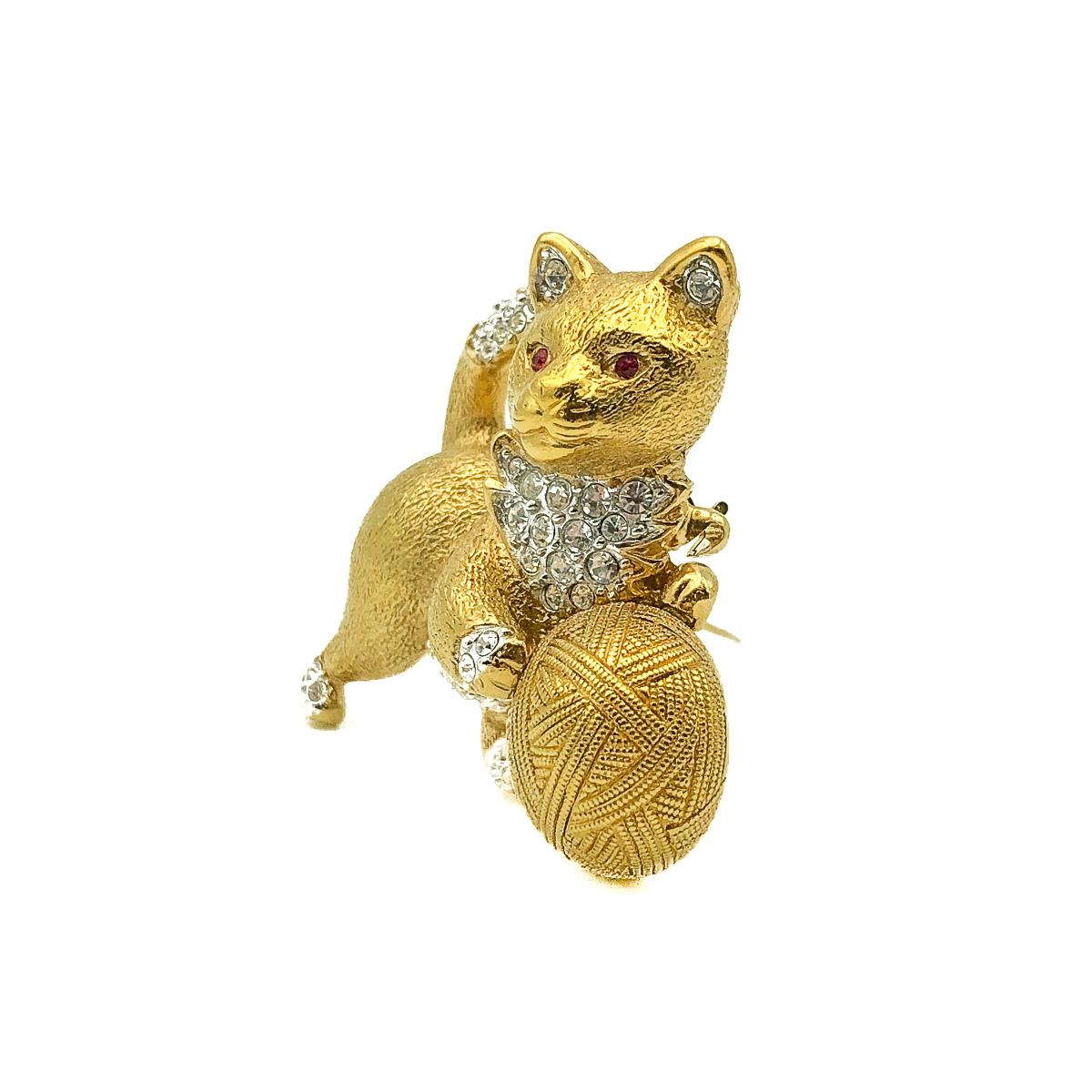 Vintage Attwood & Sawyer Cat Brooch, Crafted in gold plated metal and crystals. Featuring a crystal embellished cat or kitten playing with a large ball of wool. In very good vintage condition, signed and approx. 4.5cm. A whimsical pin perfect for a