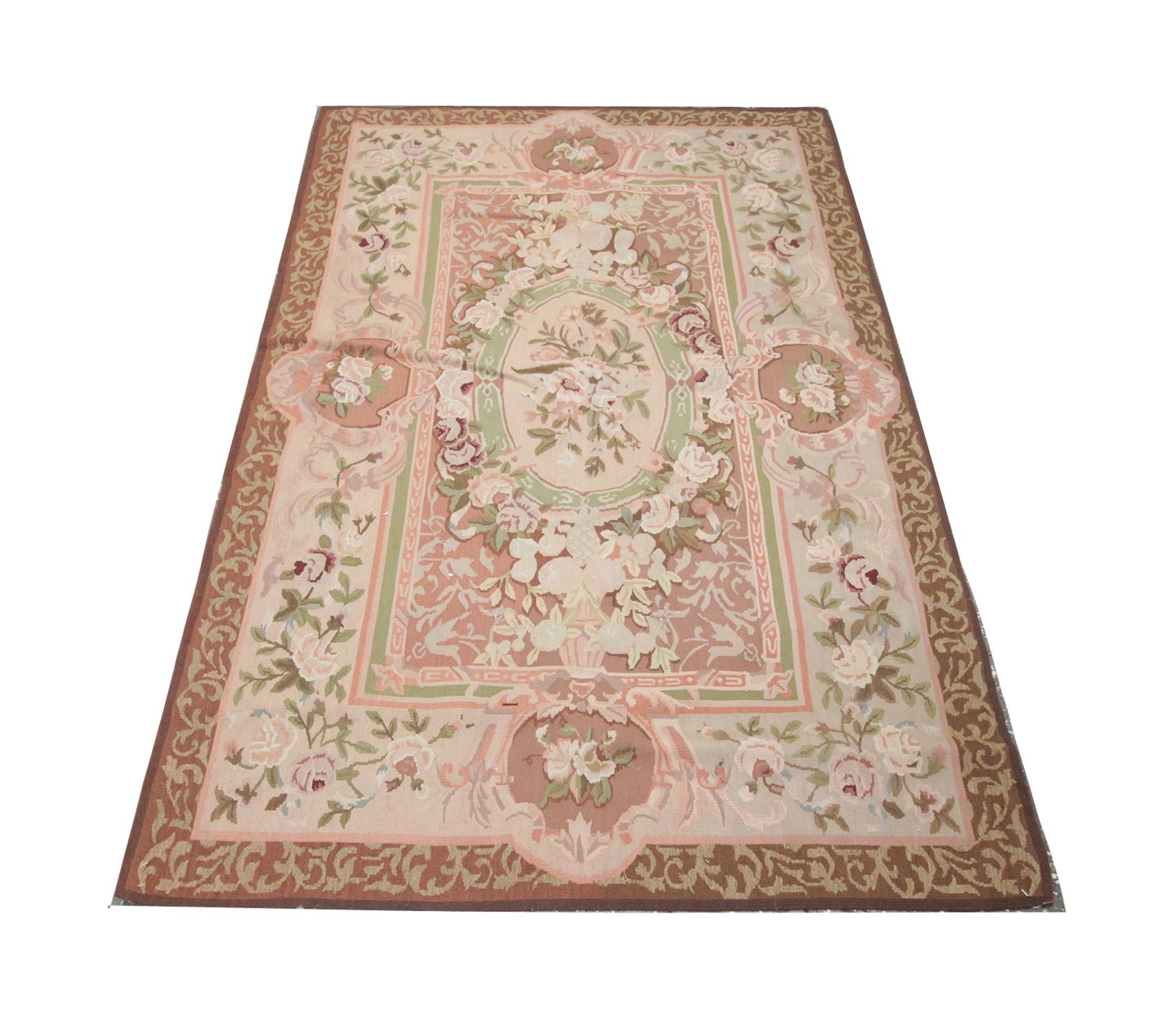 Handmade carpet with muted pink green and beige colorways, this stunning Aubusson rug reveals a large floral central medallion and foliate scrolling through the centre and border.
This high-quality Aubusson Needlepoint rug is perfect for both modern