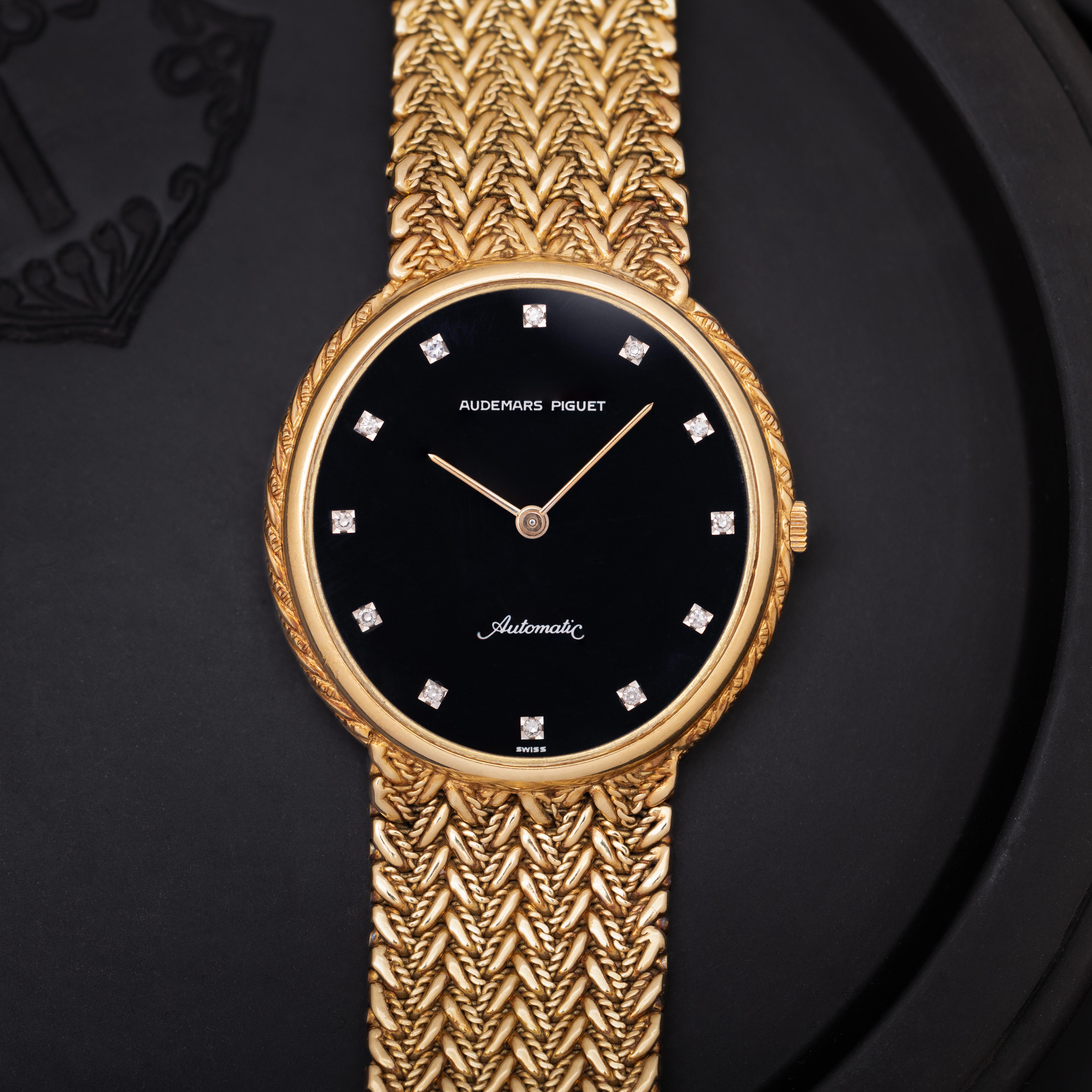 Vintage Audemars Piguet Automatic 
18k Yellow Gold
33mm Black Dial
Diamond Markers
Integrated Woven Gold Bracelet
Automatic Movement
Made in Switzerland 
91.7 grams
Fits up to a 7.5 inch wrist
c.1980s

All of our pre-owned watches are guaranteed to