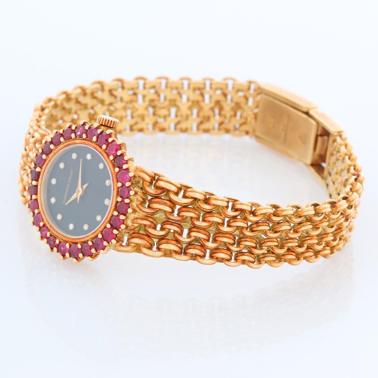 Vintage Audemars Piguet 18K Yellow Gold Ladies Watch - Manual winding. 18K Yellow gold case with a ruby bezel (22 mm) . Black dial with diamond hour markers. 18K Yellow gold bracelet. Will fit up to a 6 1/2 inch wrist.  Pre-owned with Audemars