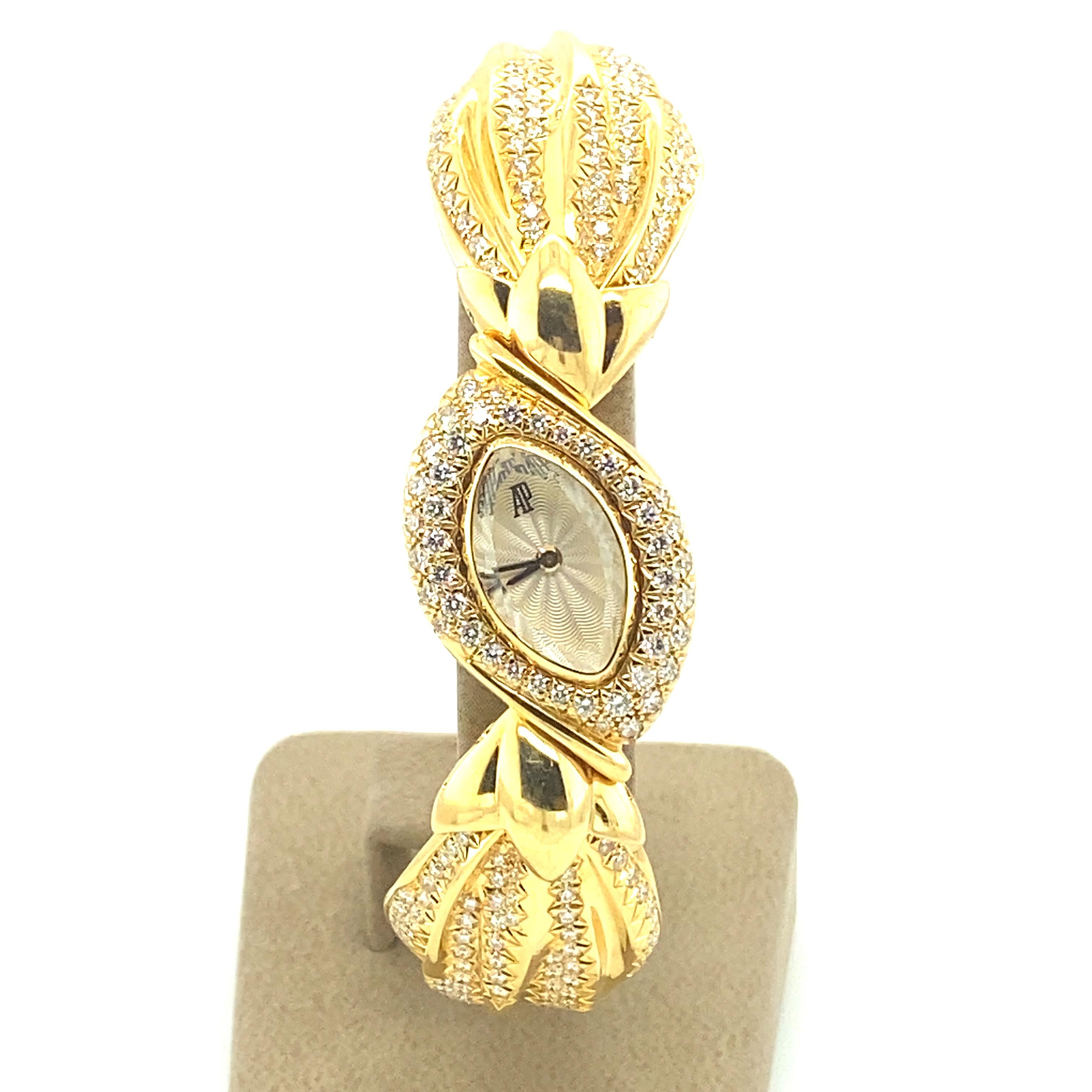 Rare Audemars Piguet ladies cocktail watch ref. 25468. Bow-shaped case and bracelet in yellow gold 18 karat. The three moving elements are pavé set with a total of 222 full brilliant-cut diamonds totalling approximate 2.20 ct of diamonds. 

Silver