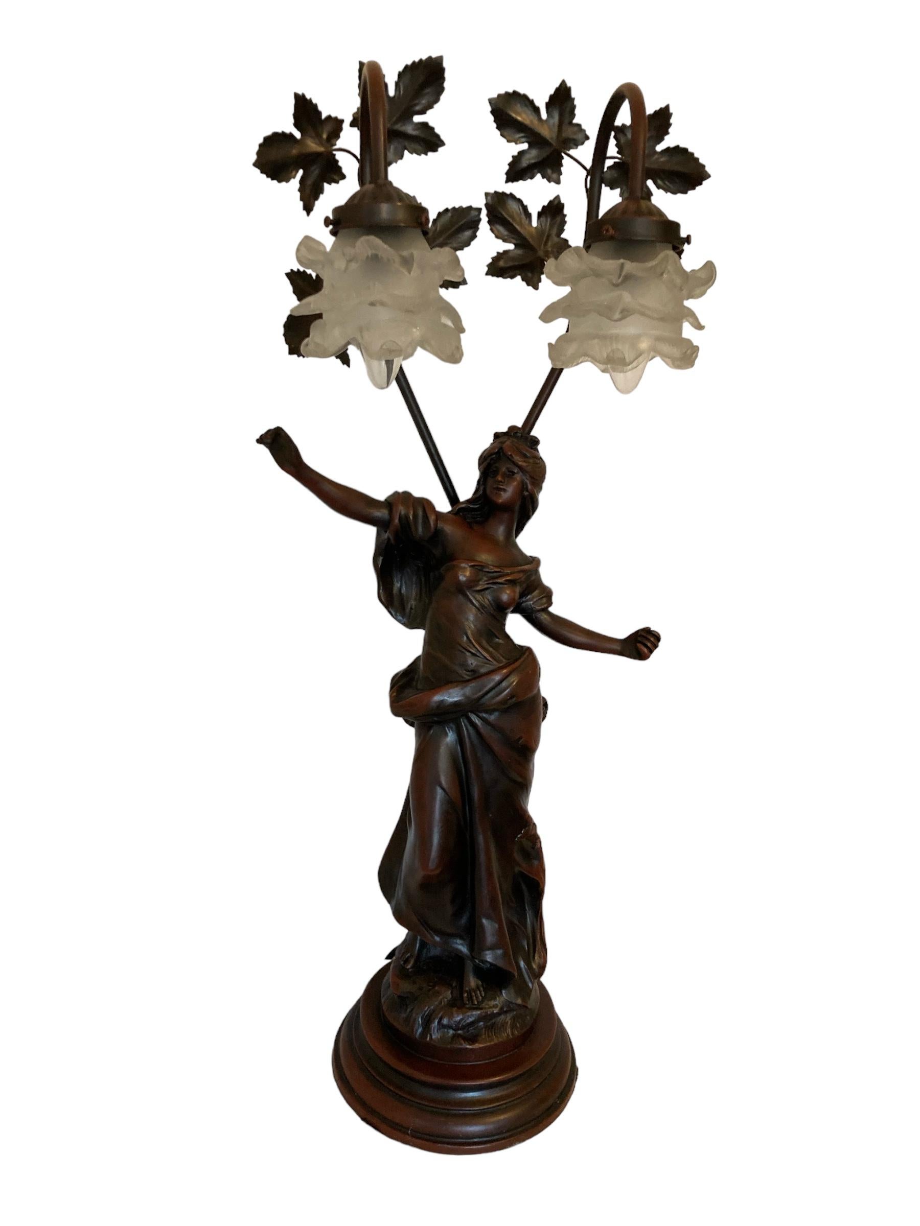 Vintage Auguste Moreau figural sculpture table lamp with glass shades. Sculpture is made of spelter, with an antique bronze finish. Sculptures by Louis Auguste Moreau (1855-1919) who, together with his brother Hippolyte Francois Moreau, produced