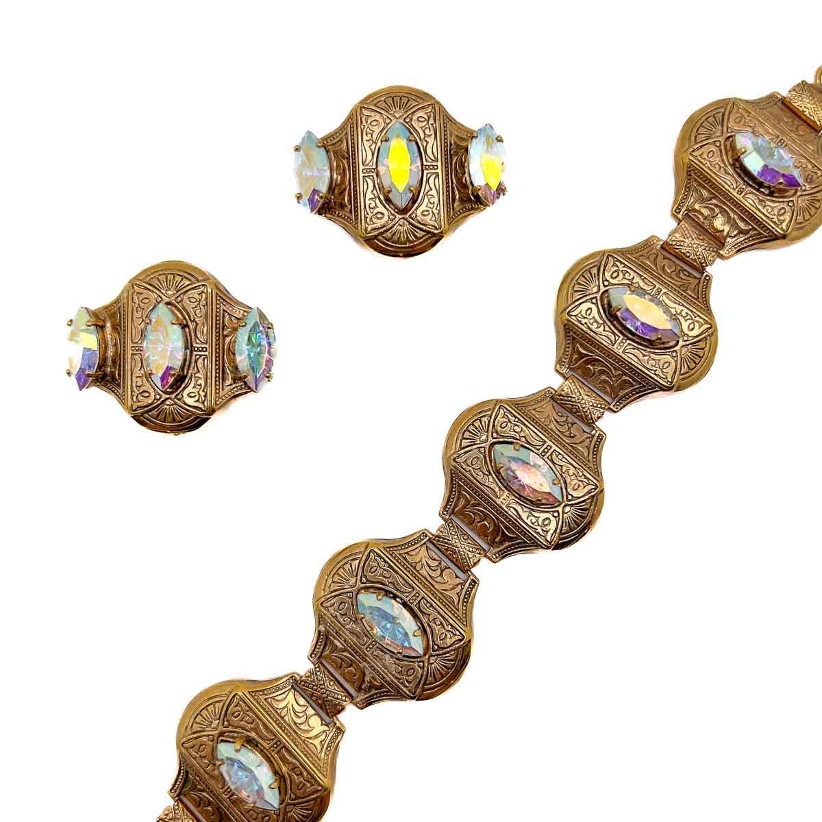 A Vintage Aurora Borealis Bracelet and earrings Set. A wonderfully crafted demi parure featuring intricately patterned panels set with navette aurora borealis crystals. The combination of an earring and cuff making for an ultra stylish duo.

An