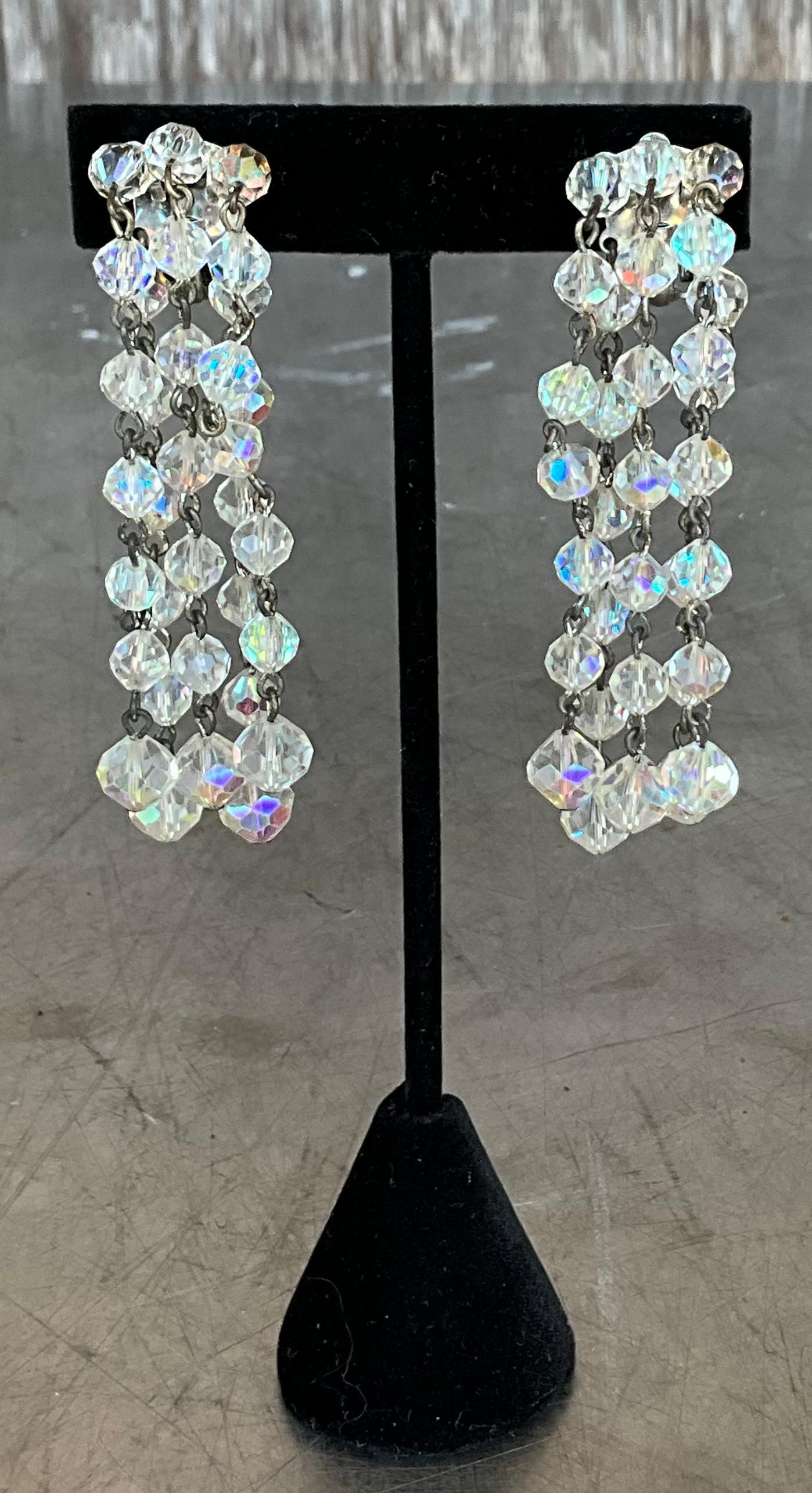 Add a touch of vintage glamour to your jewelry collection with these stunning Aurora Borealis crystal clip-on earrings. Featuring faceted crystals that catch the light beautifully, these earrings shimmer with an array of colors, from soft pastels to
