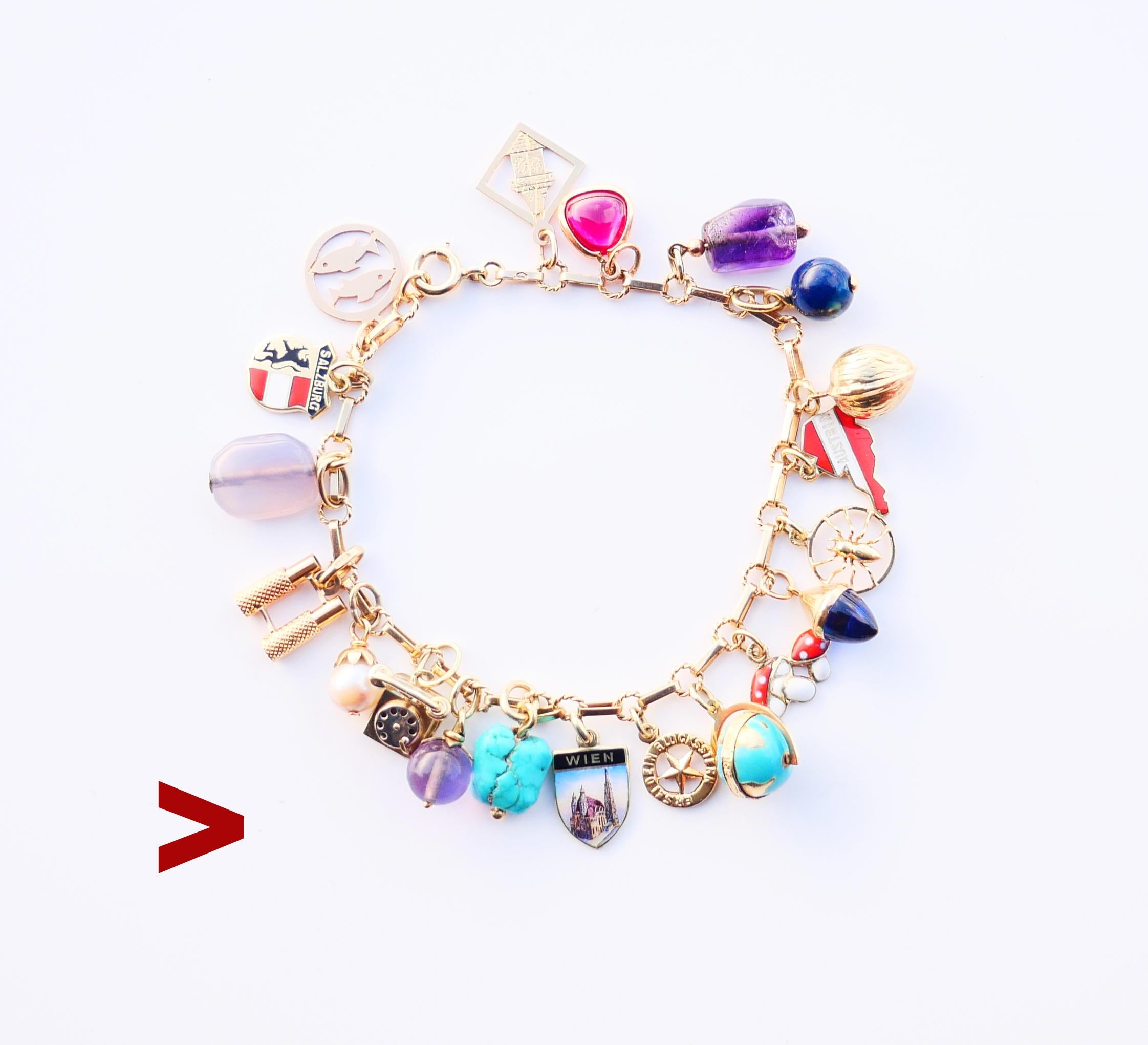 Österreichische Kette mit einer Reihe von 20 meist massiven 14k Gelbgold Charme / Anhänger und mehrere in massivem 18K Gold. Fünf Anhänger aus emailliertem Gold. Sieben in massivem Gold . Acht Anhänger mit Gold und Steinen: Roter Rubin, Lapislazuli,