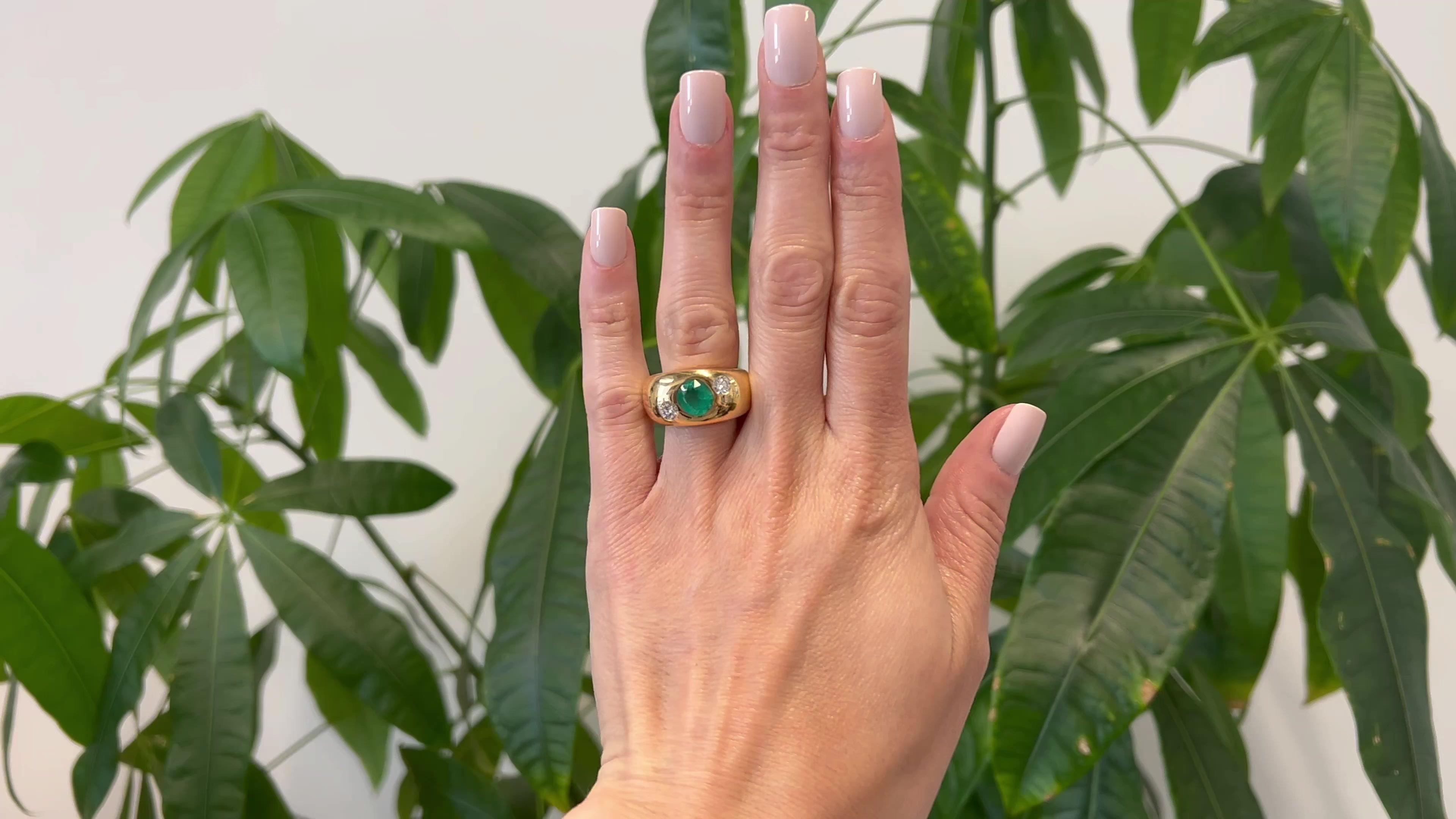 One Vintage Austrian Emerald and Diamond 18k Yellow Gold Three Stone Ring. Featuring one cushion mixed cut emerald weighing approximately 1.80 carats. Accented by two round brilliant cut diamonds with a total weight of approximately 0.60 carat,