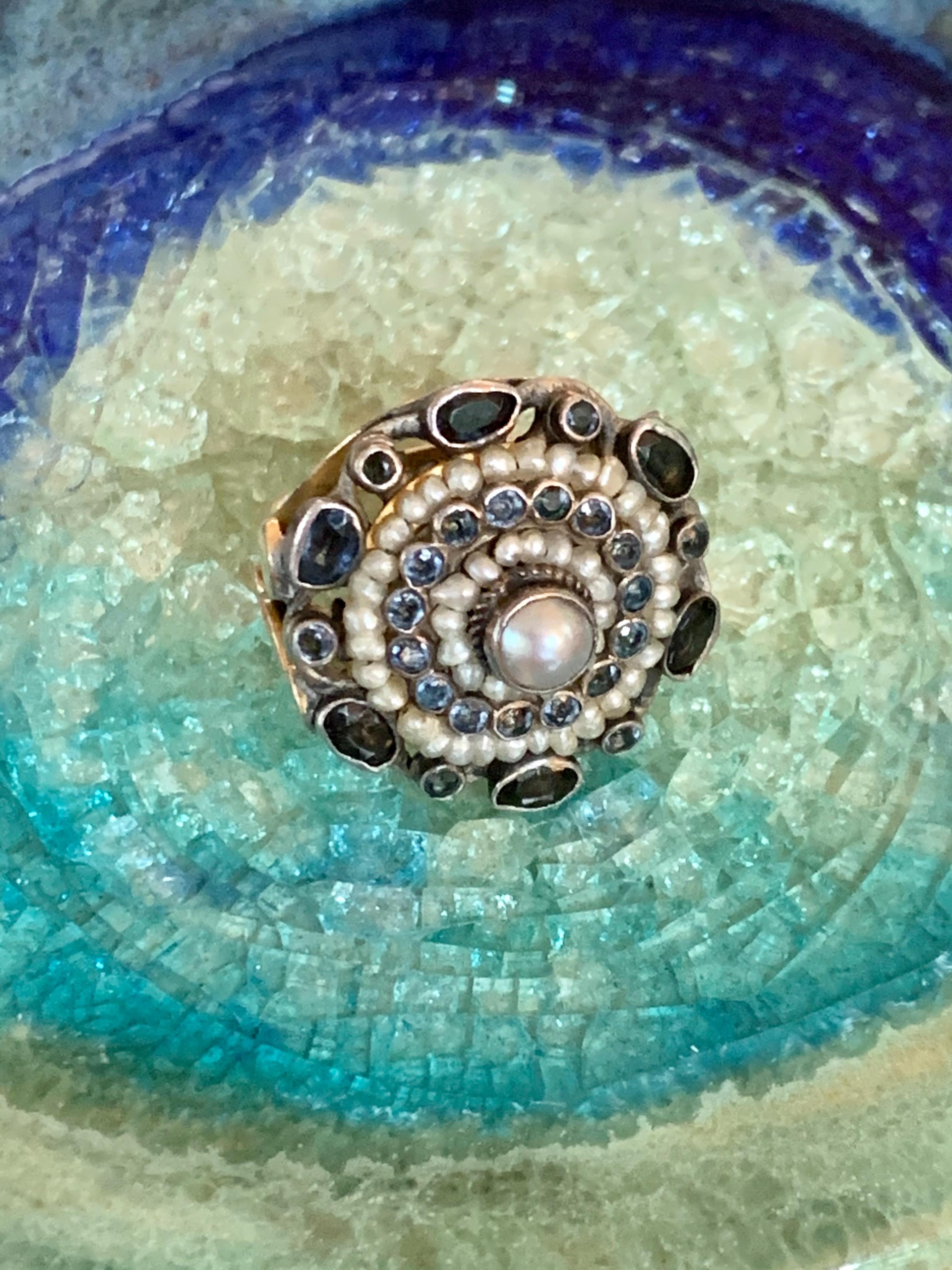 This beautiful Austro-Hungarian ring features Sapphires, Seed Pearls and blue glass clustered together in a circle which measures approximately 7/8