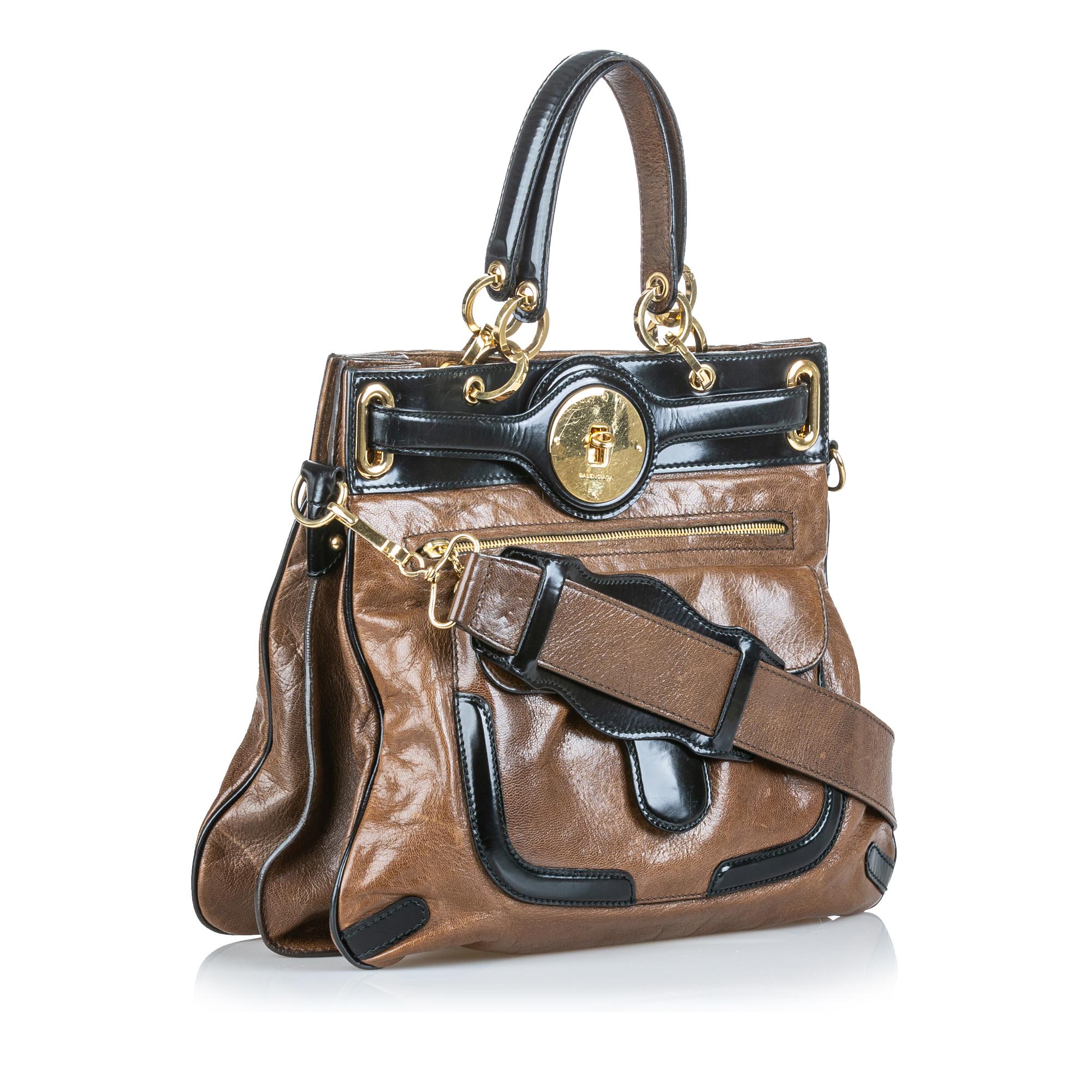 The Moon Satchel features a leather body, front exterior flap and zip pockets, flat leather top handles, a flat leather strap, a cinched top with a twist lock closure, and an interior zip pocket. It carries as B+ condition rating.

Inclusions: 
This