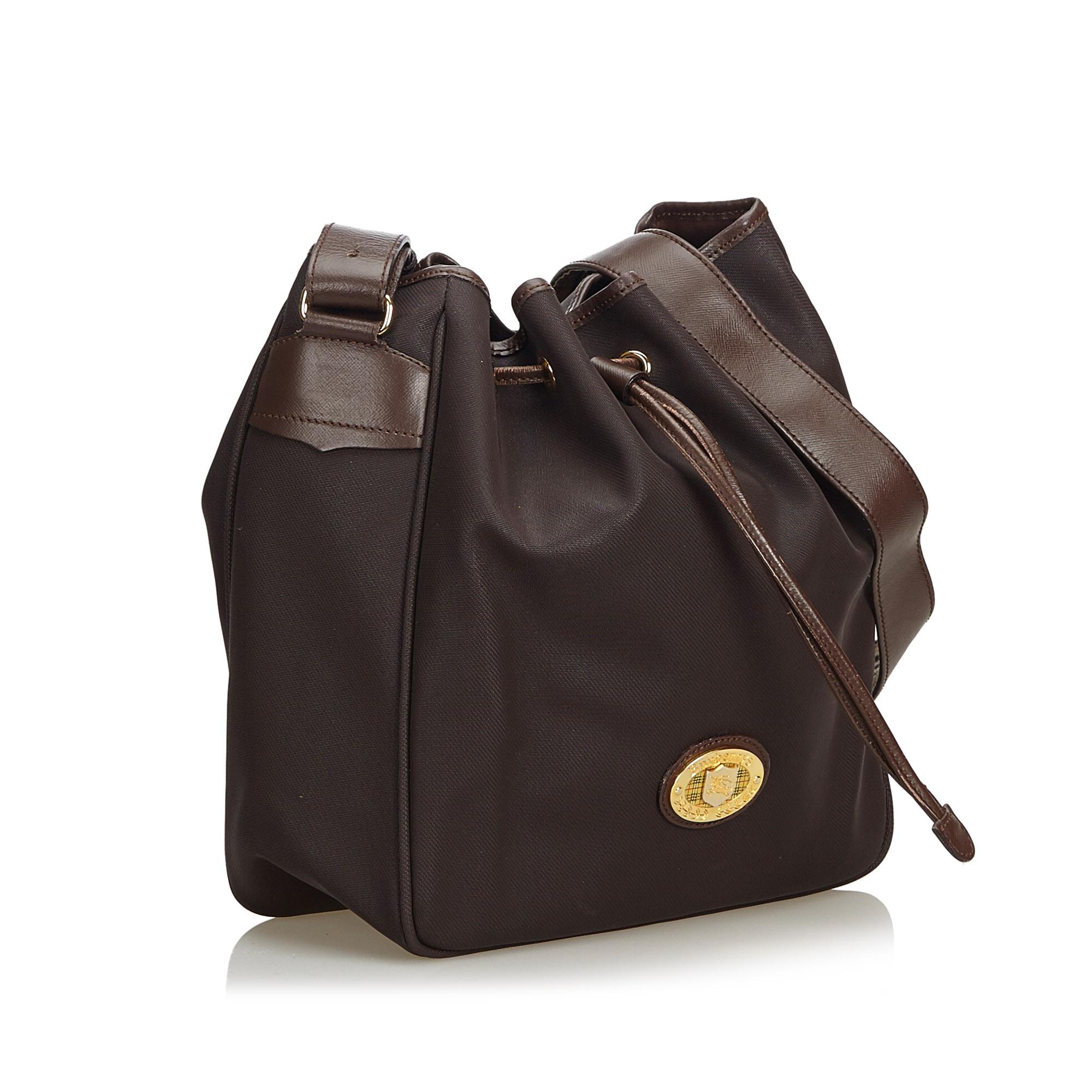 This bucket bag features a nylon body, a flat leather strap, a top drawstring closure, and an interior zip pocket. It carries as B condition rating.

Inclusions: 
Dust Bag

Dimensions:
Length: 29.00 cm
Width: 25.00 cm
Depth: 11.50 cm
Shoulder Drop: