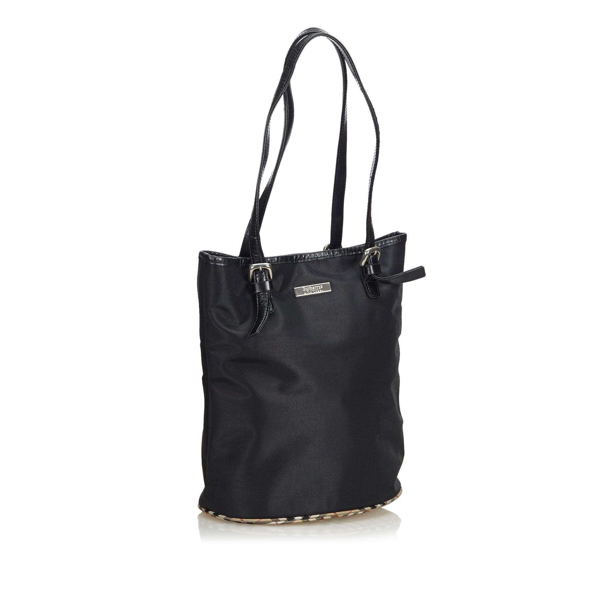 This tote bag features a nylon body with canvas bottom, a flat leather straps, an open top, and an interior zip pocket It carries as B condition rating.

Inclusions: 
This item does not come with inclusions.

Dimensions:
Length: 28.00 cm
Width: