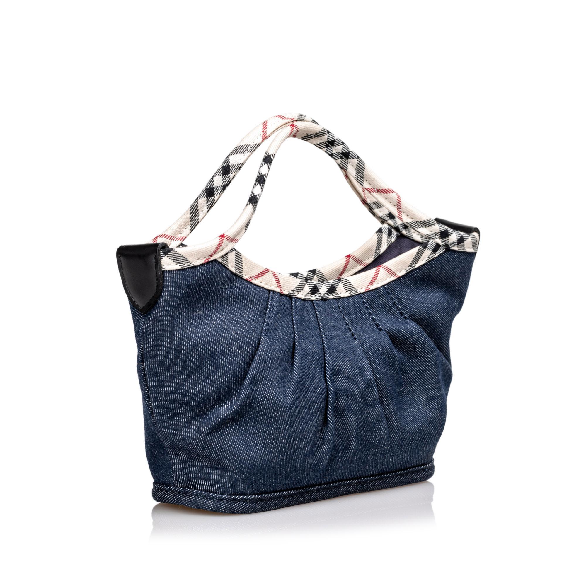 This handbag features a denim body with house check detail, flat handles, an open top with a magnetic closure, and an interior slip pocket. It carries as AB condition rating.

Inclusions: 
This item does not come with