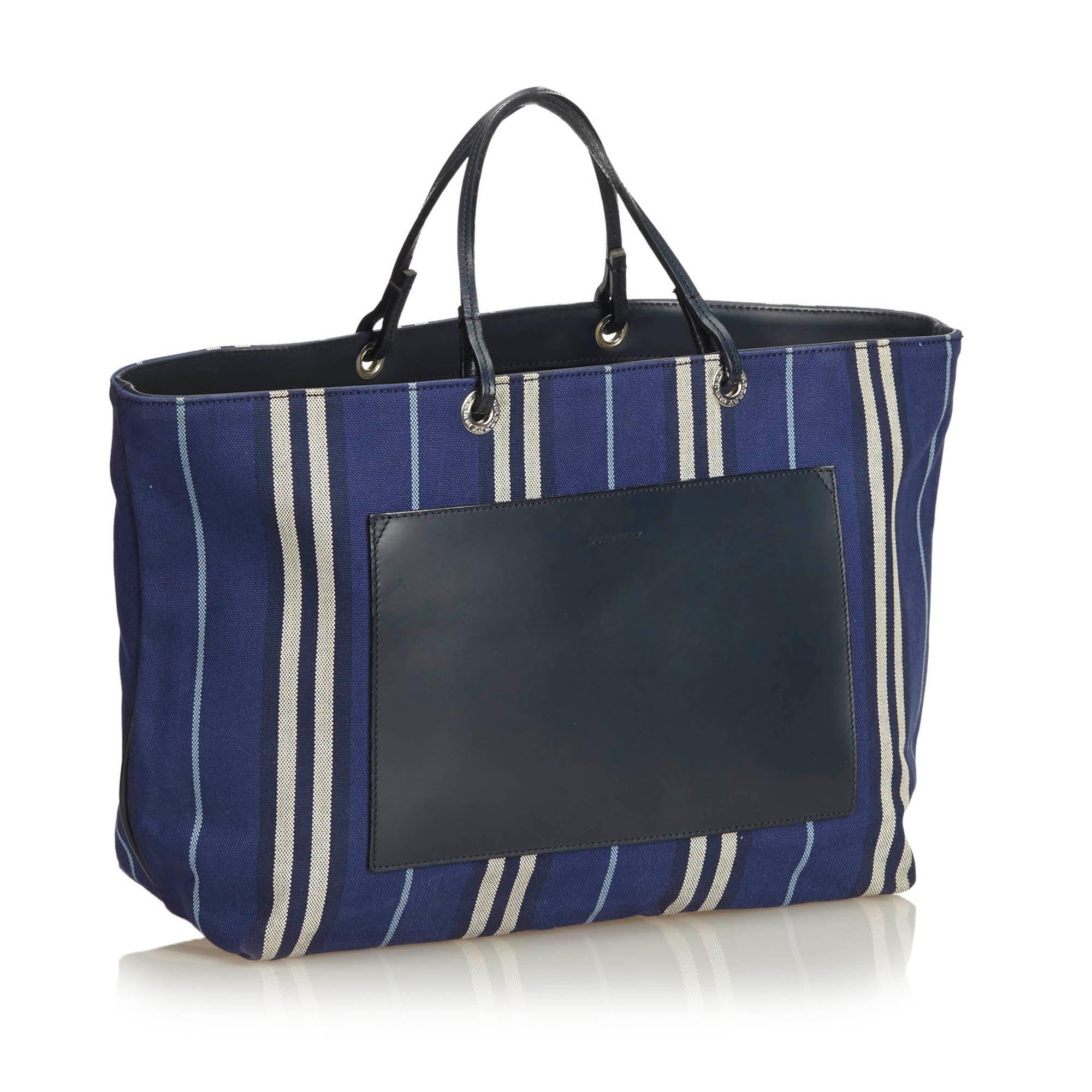 This tote bag features a striped jacquard body with leather trim, flat leather straps, open top, and an exterior slip pocket. It carries as AB condition rating.

Inclusions: 
This item does not come with inclusions.

Dimensions:
Length: 26.50