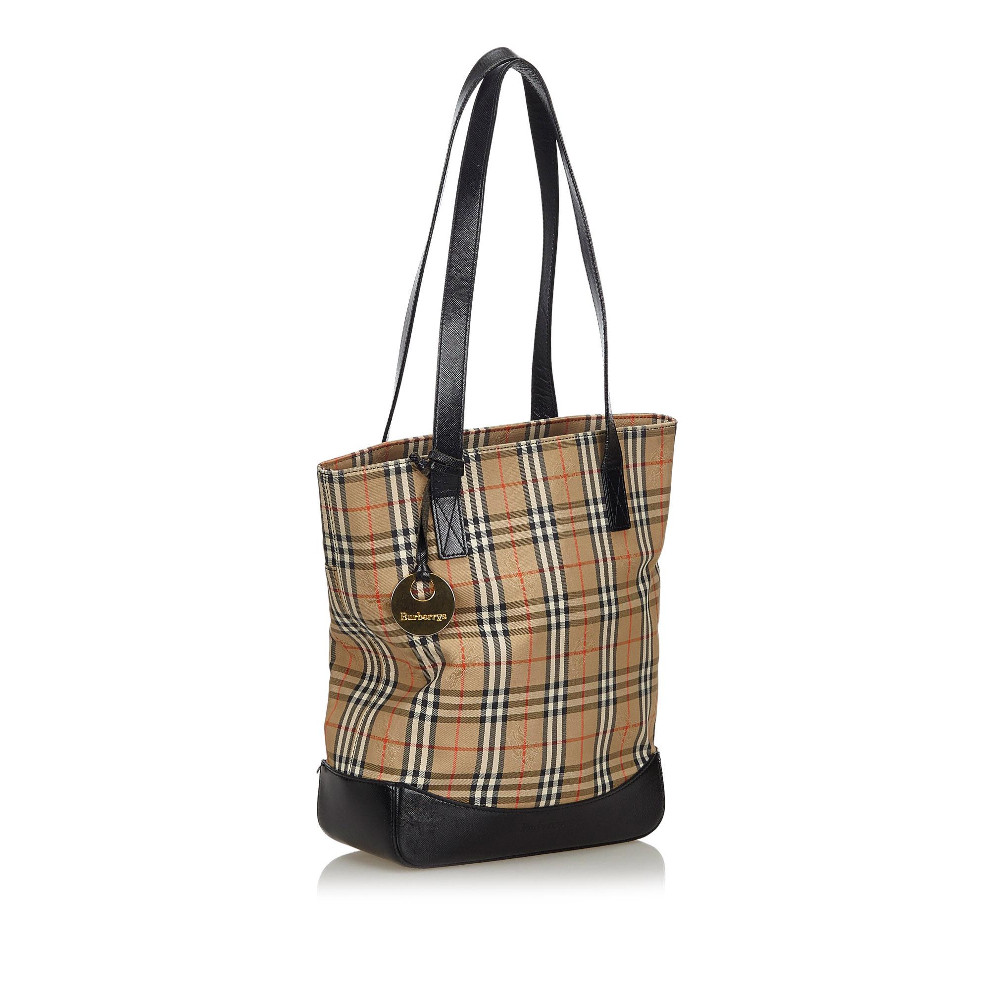 This tote bag features a canvas body with leather trim, a flat leather straps, an open top with a magnetic snap button closure, and an interior zip pocket. It carries as B+ condition rating.

Inclusions: 
This item does not come with