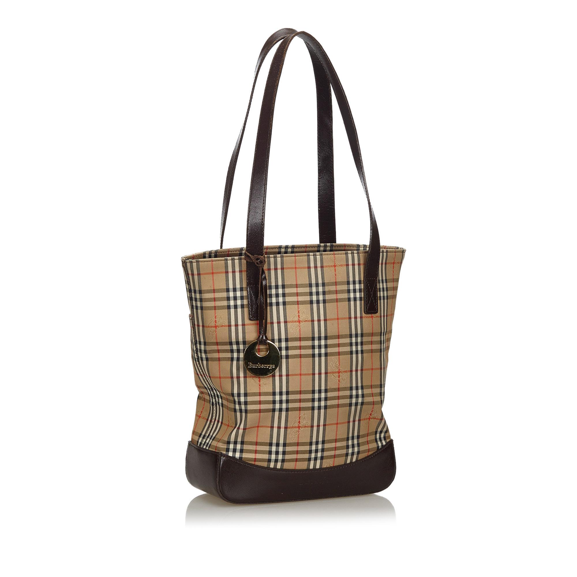This tote bag features a canvas body with leather trim, a flat leather straps, an open top with a magnetic snap button closure, and an interior zip pocket. It carries as B condition rating.

Inclusions: 
This item does not come with