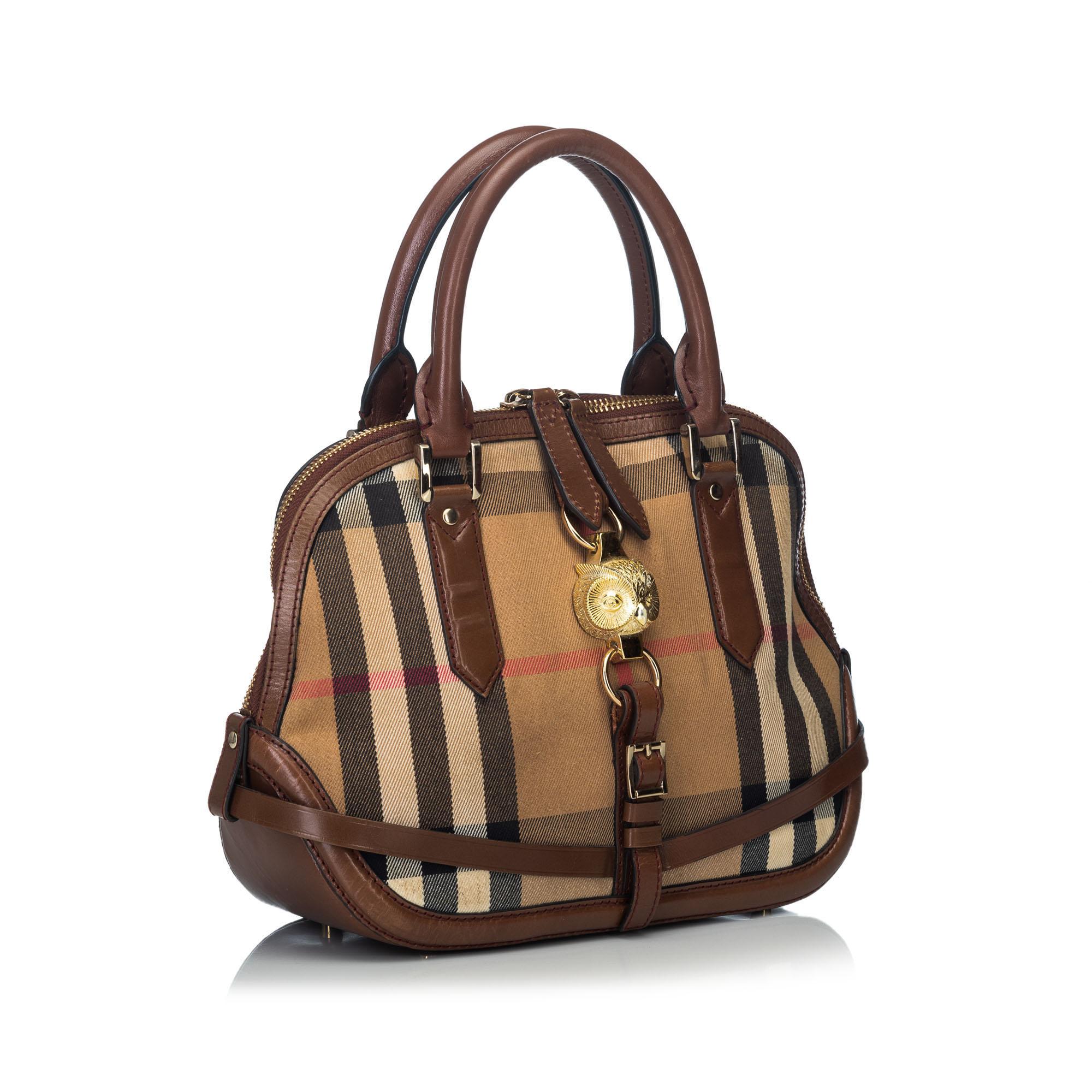 This satchel features a canvas body with leather trim, an owl detail, rolled leather handles, a flat strap, a tip zip closure, and an interior zip pocket. It carries as B condition rating.

Inclusions: 
This item does not come with