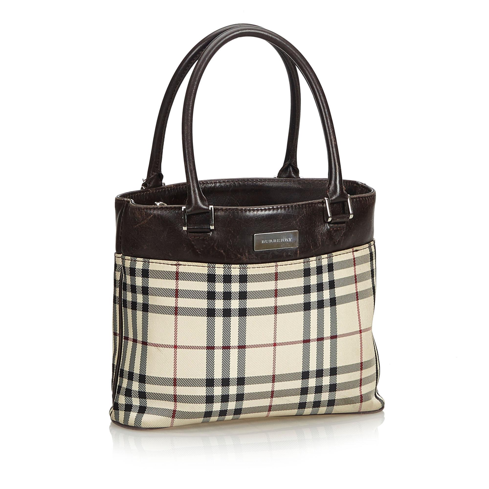 This tote bag features a coated canvas body with leather trim, rolled leather handles, an open top, an interior zip compartment, and an interior slip pocket. It carries as B condition rating.

Inclusions: 
This item does not come with