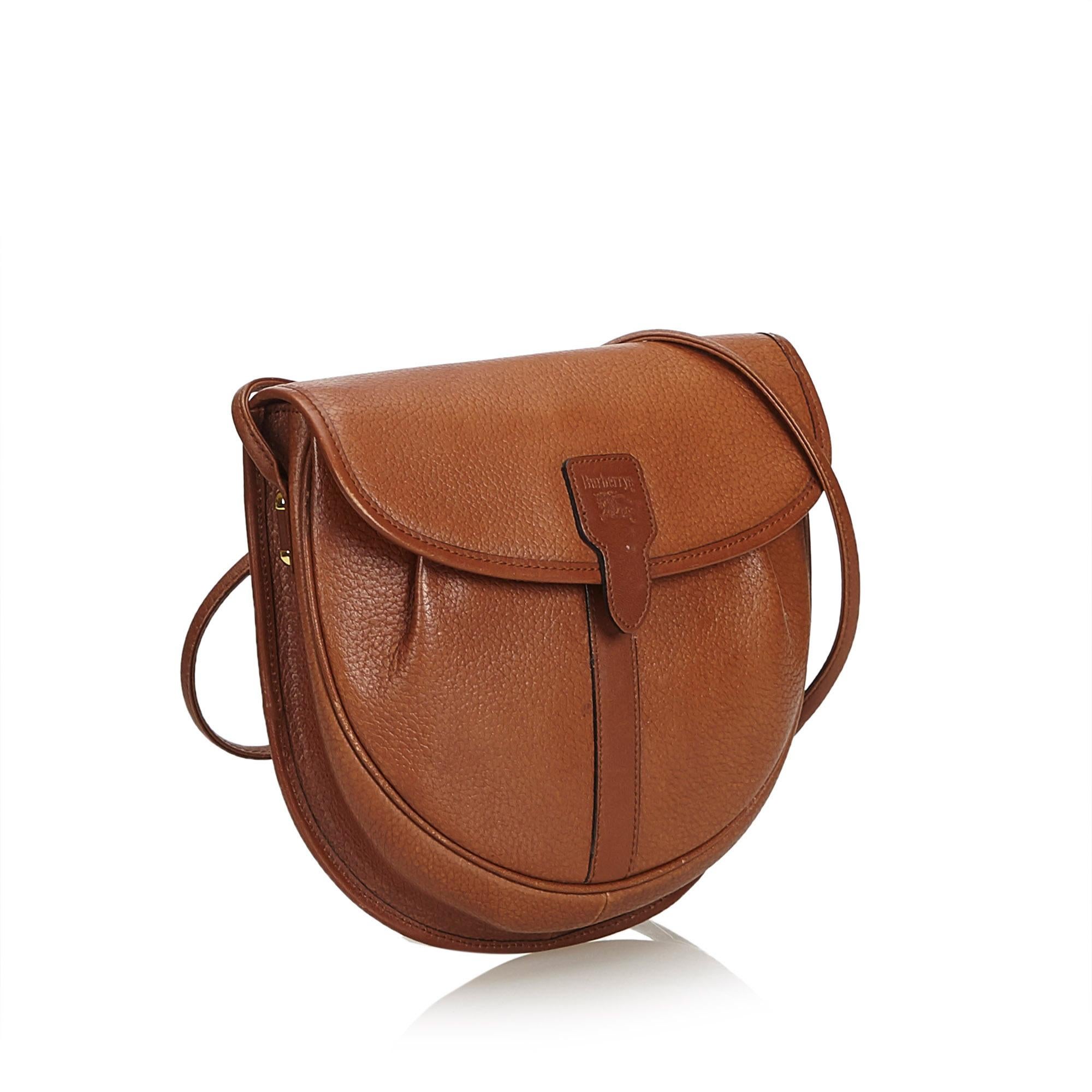 This crossbody bag features a leather body, an adjustable flat leather strap, a top flap with a magnetic snap button closure, and an interior open pocket. It carries as B+ condition rating.

Inclusions: 
This item does not come with